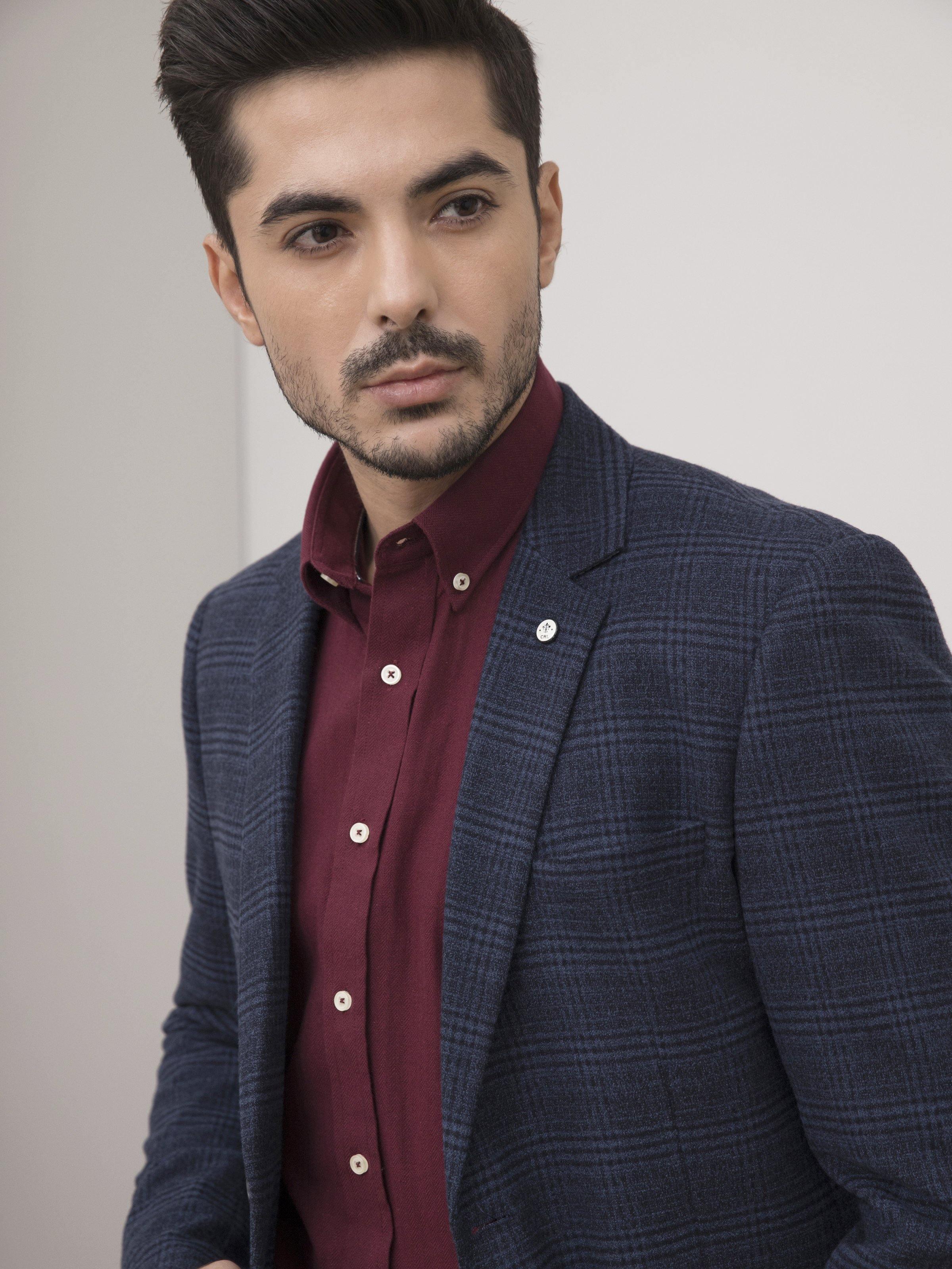 Navy wool coat close-up: two-button placket, notched lapel and plaid weave