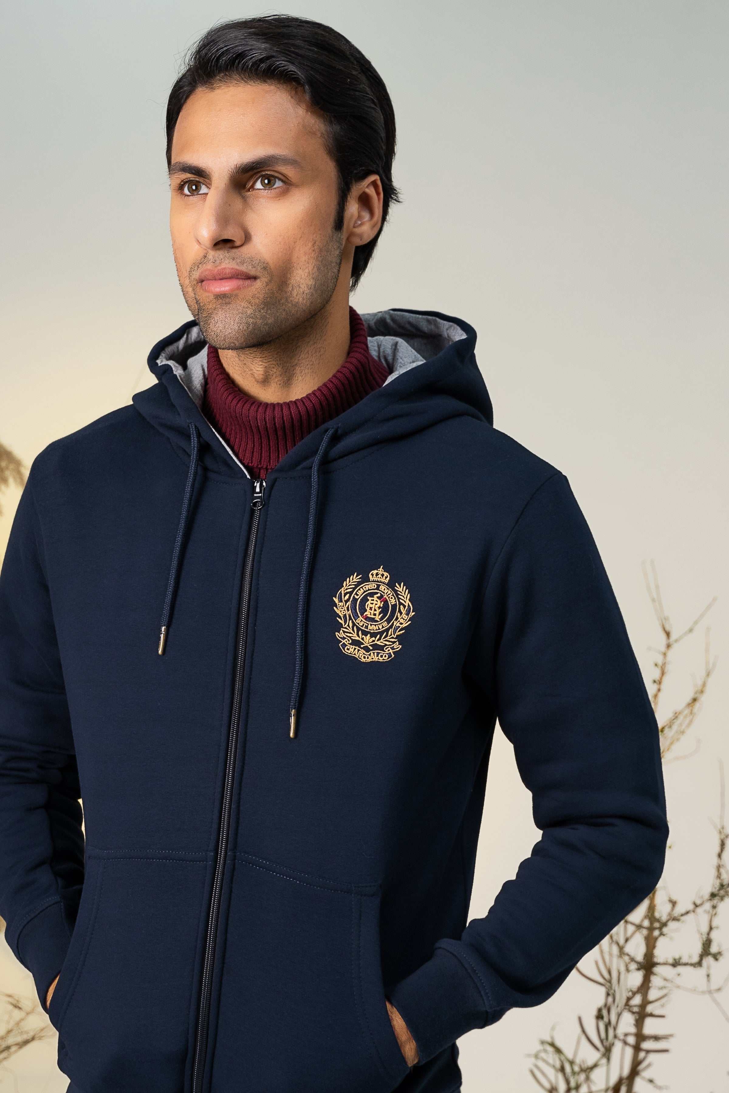 Navy zip-up hoodie with hood, zip front, and chest crest