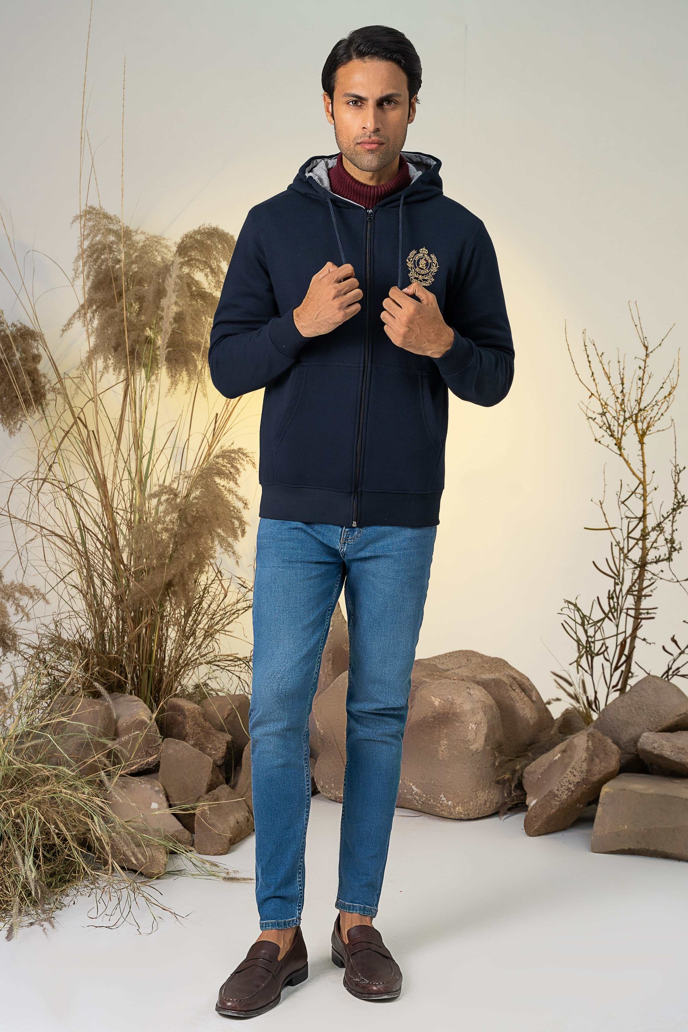 Navy zip-up hoodie with hood and chest crest