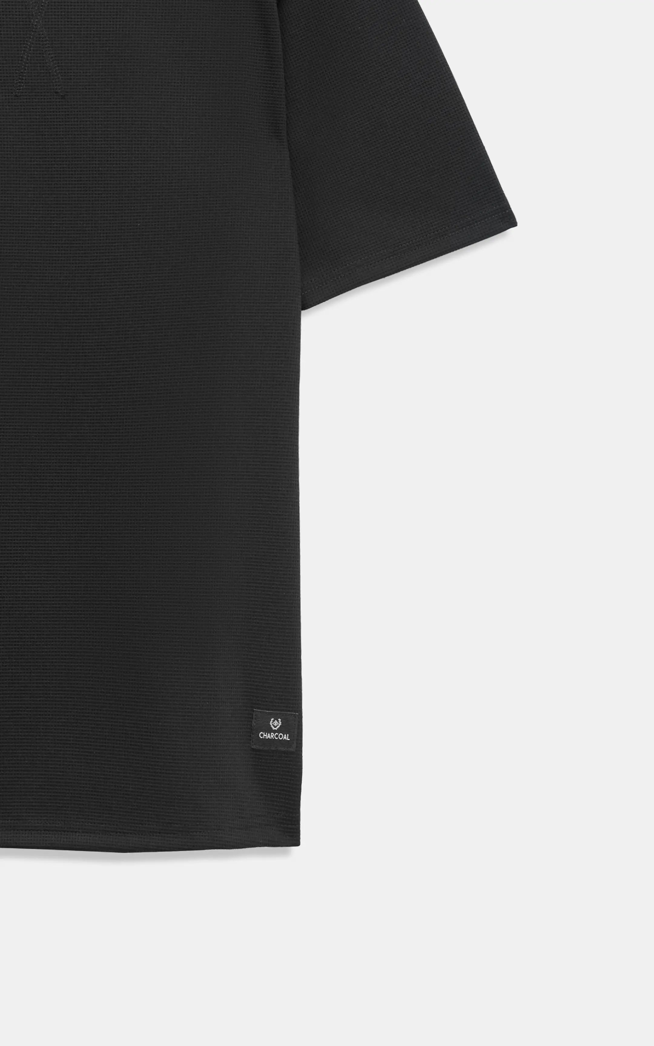 Black oversize crew neck T-shirt hem detail with small logo patch