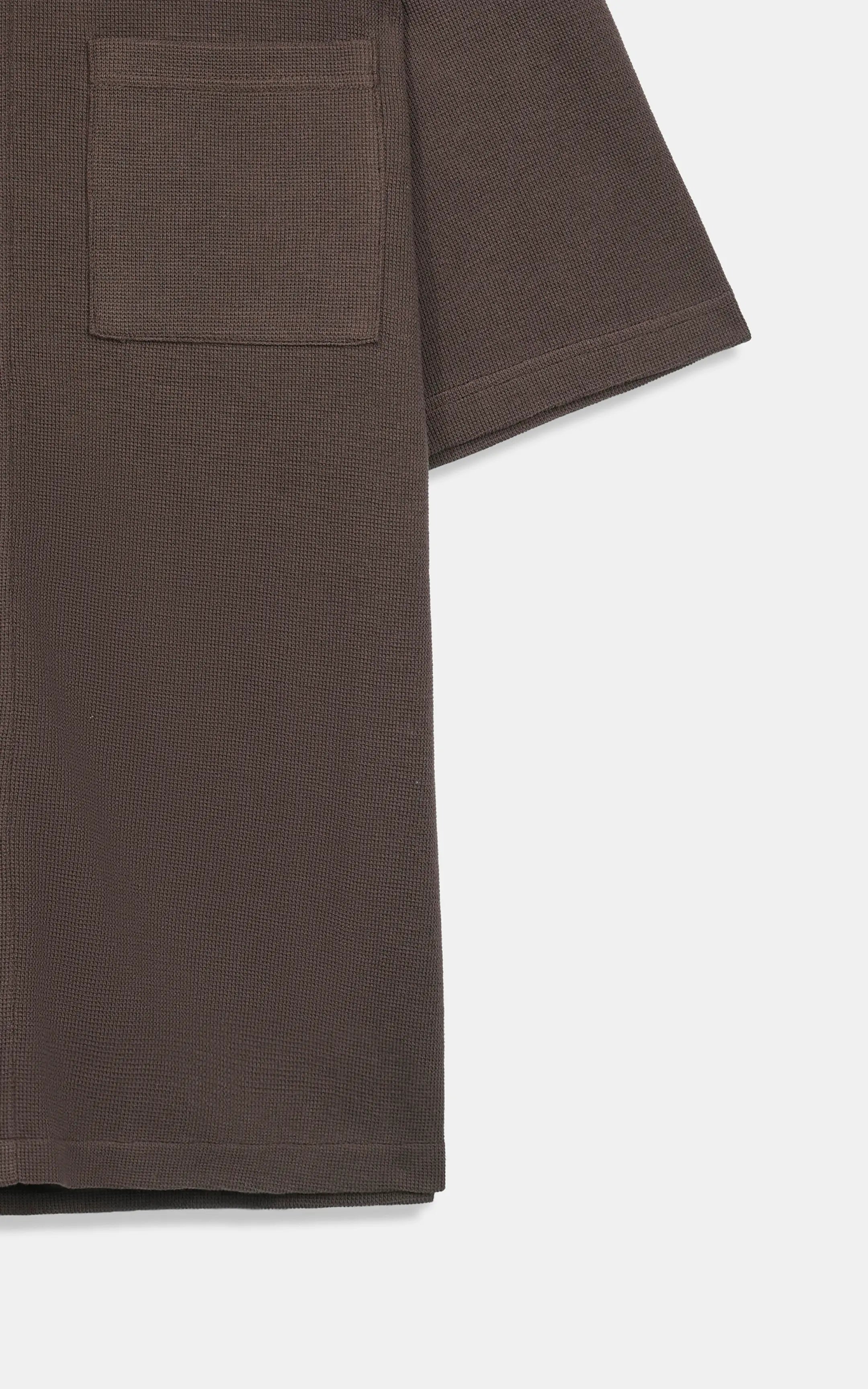Brown knit shirt hem detail with chest pocket and short sleeve cuff