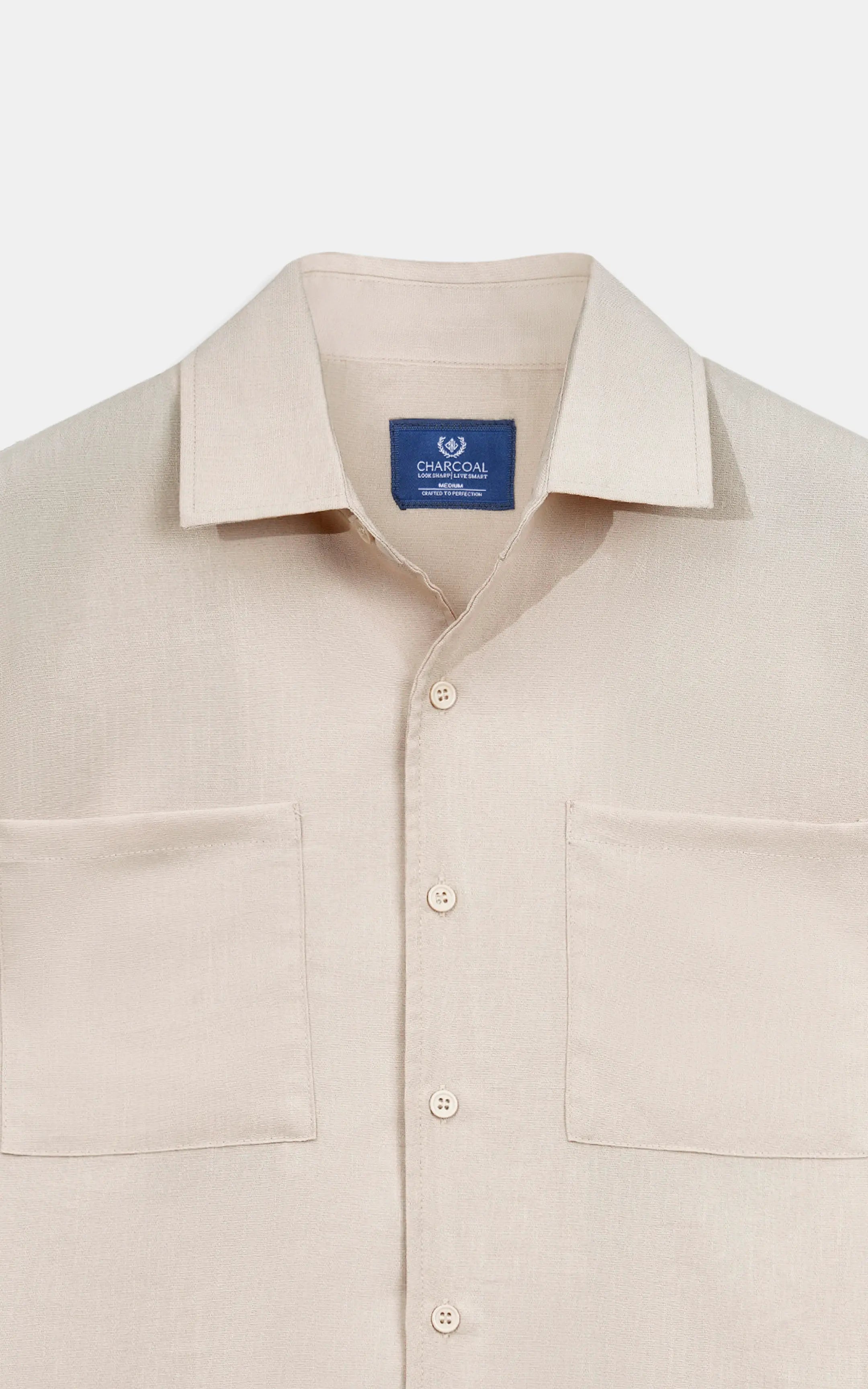 Beige regular-collar shirt close-up with button placket and brand neck label