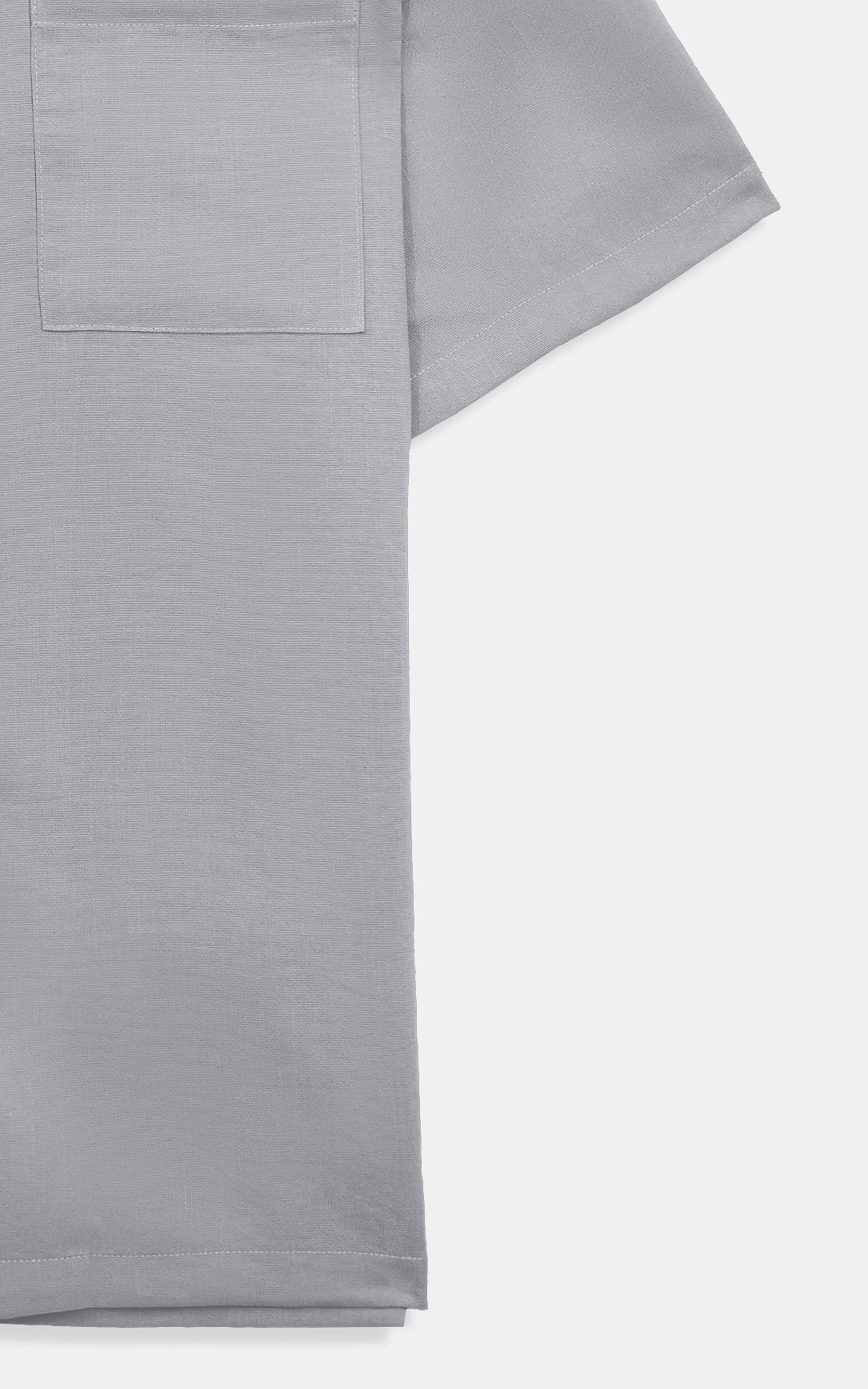 Light grey short-sleeve shirt fabric close-up with hem and side seam