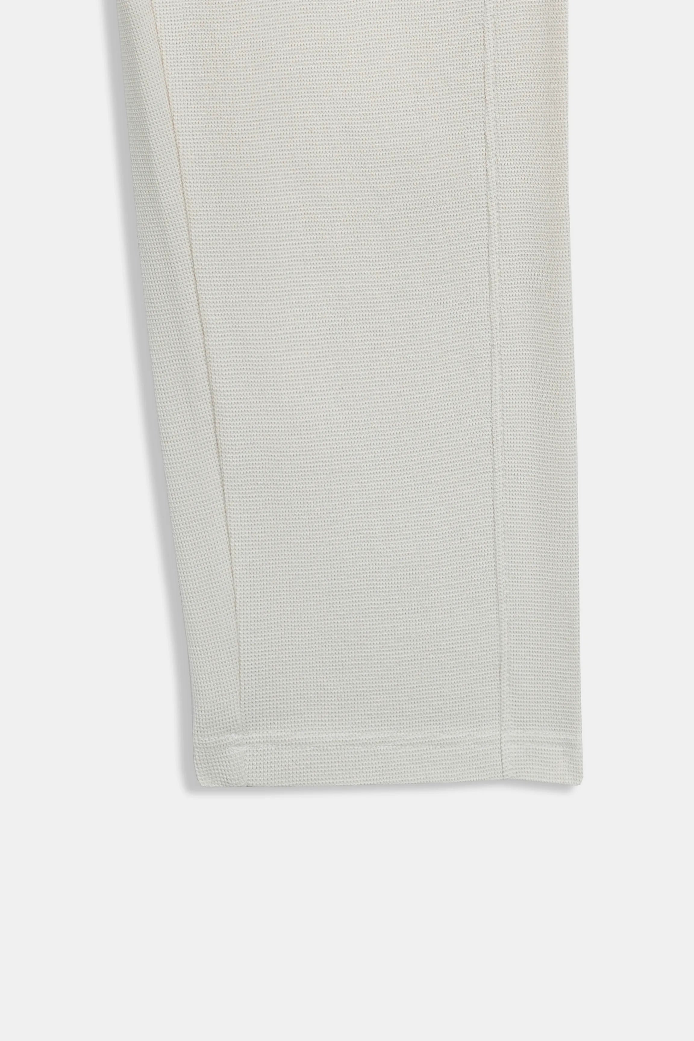 Off-white knit fabric swatch with fine textured weave