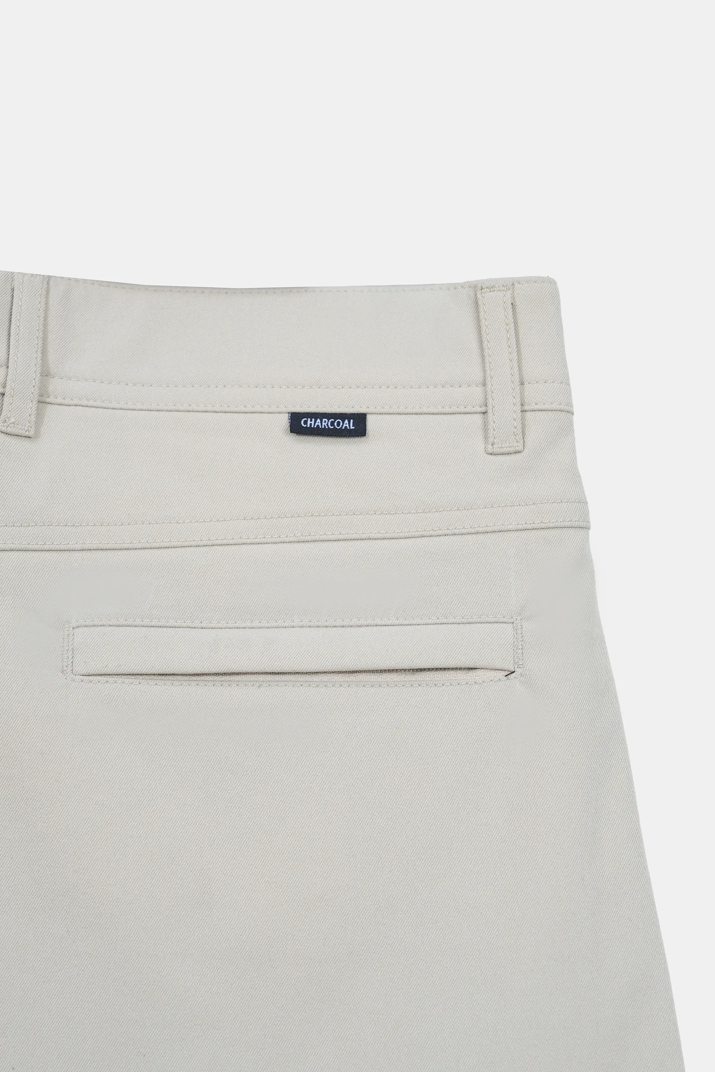 Light beige pants front with waistband label reading CHARCOAL and coin pocket