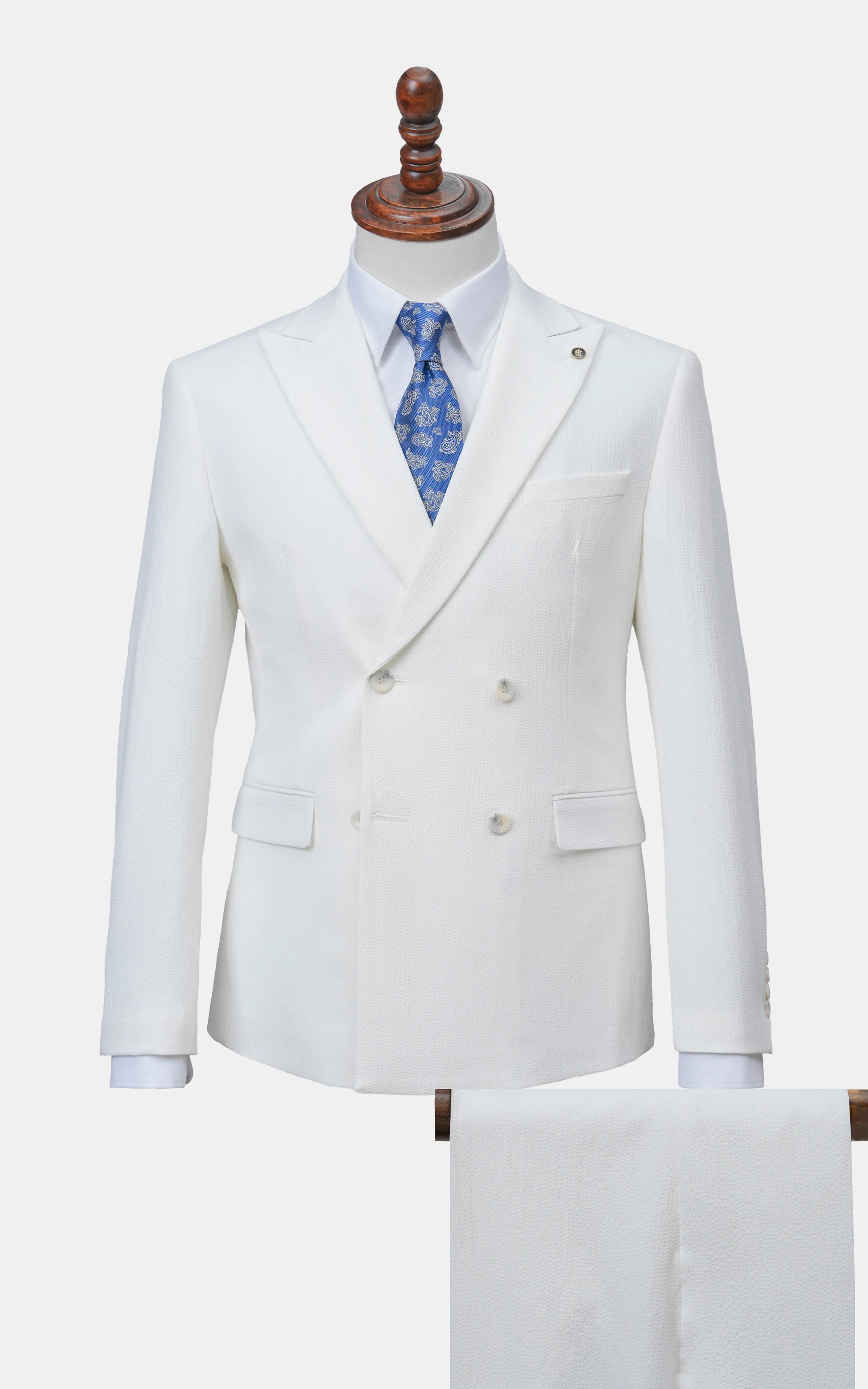 White double-breasted suit jacket and matching trousers on mannequin with blue tie