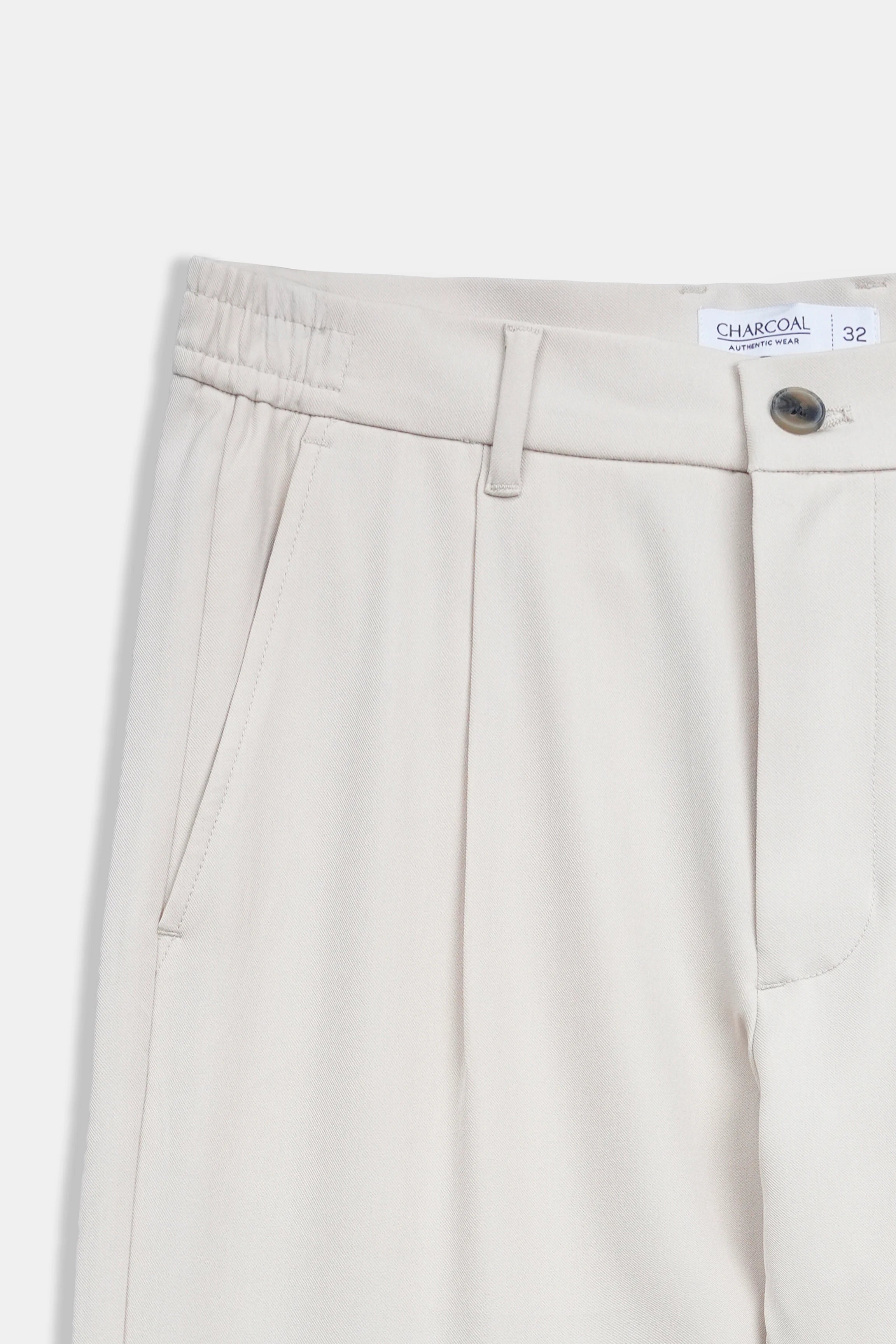 Beige casual pants waistband with belt loops, button closure, and pleat details