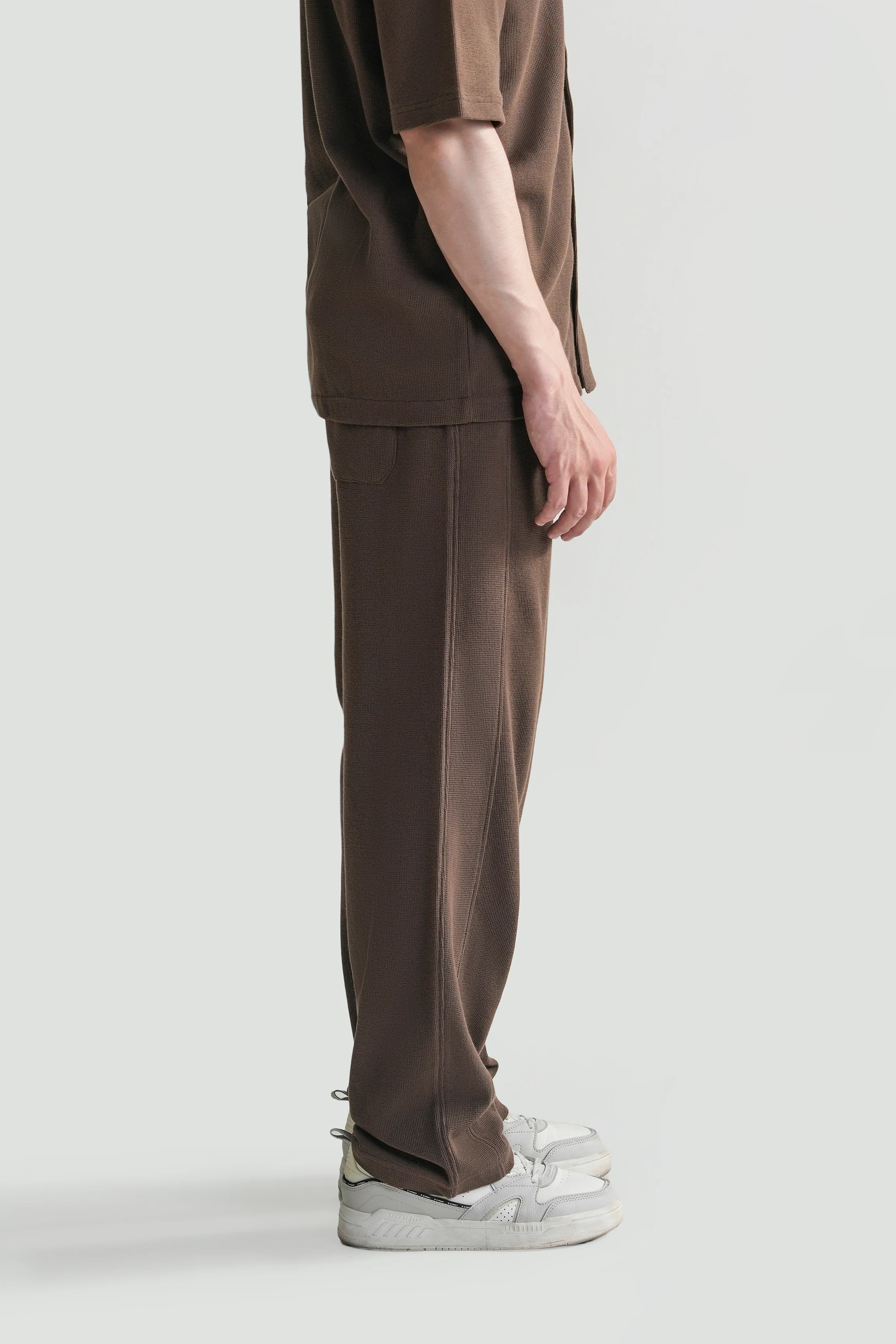 Brown loose knit trousers with drawstring waist and relaxed straight leg