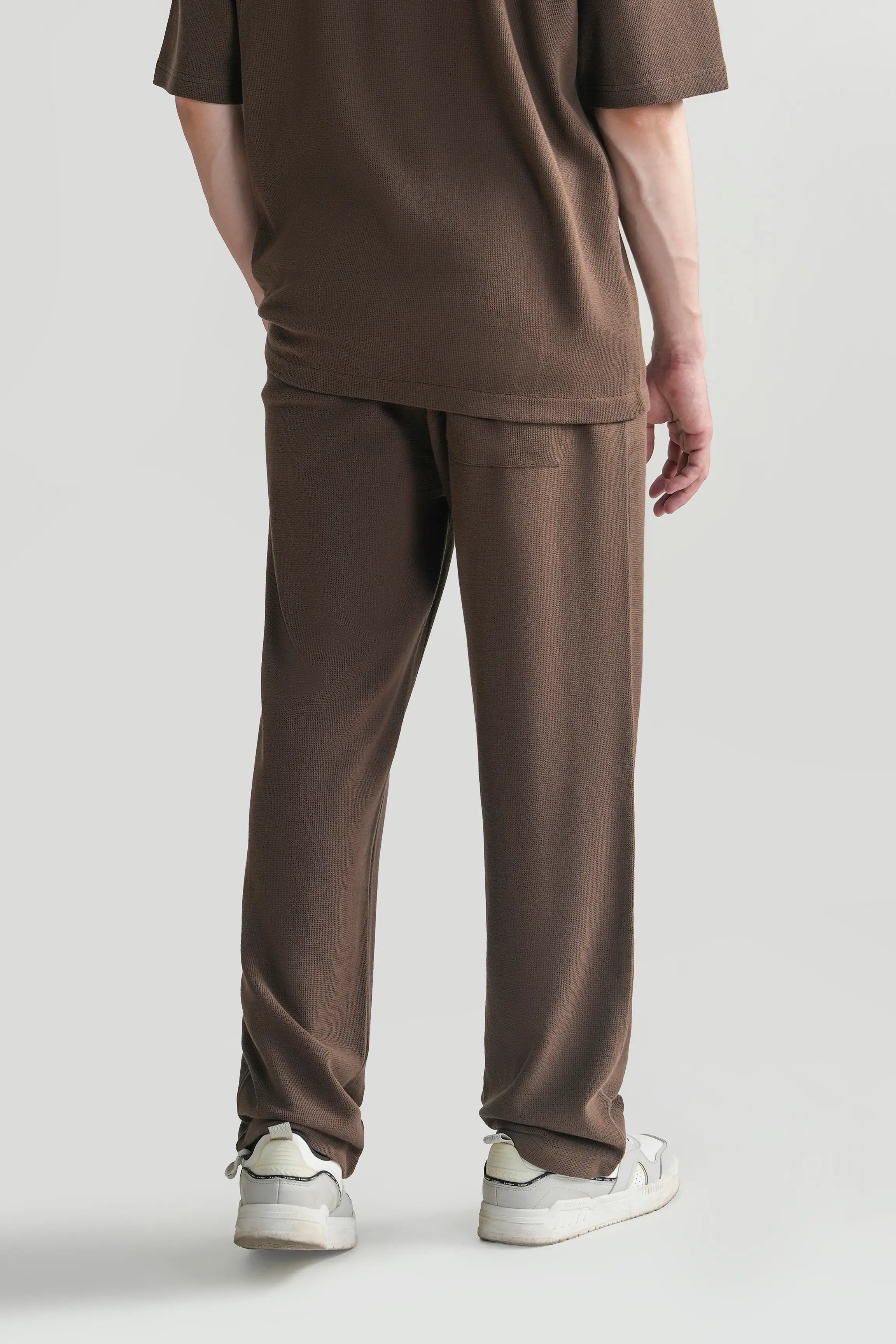 Brown knit trousers with side pockets and elastic waist drawstrings