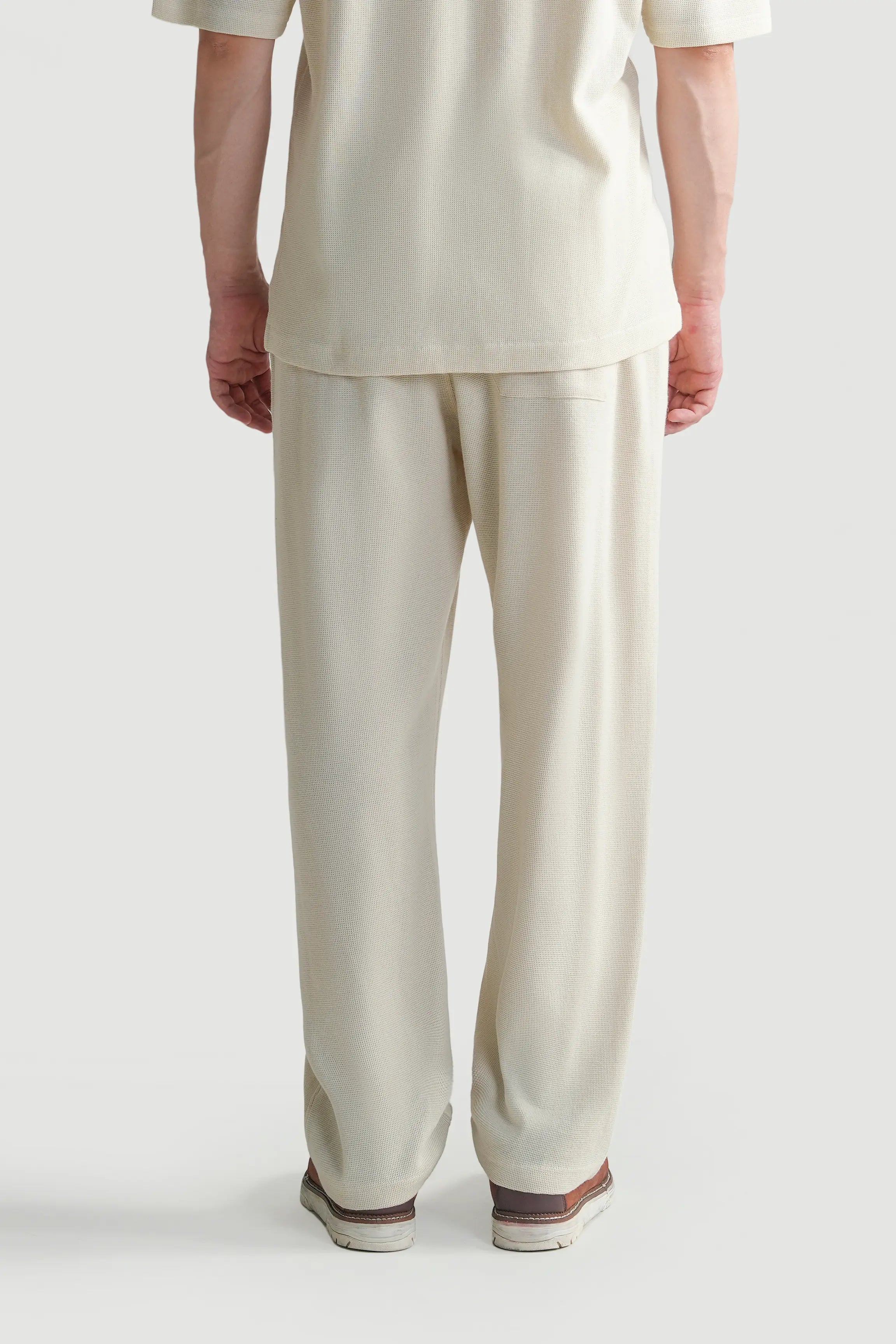 Off-white knit trousers with elastic waist and straight leg