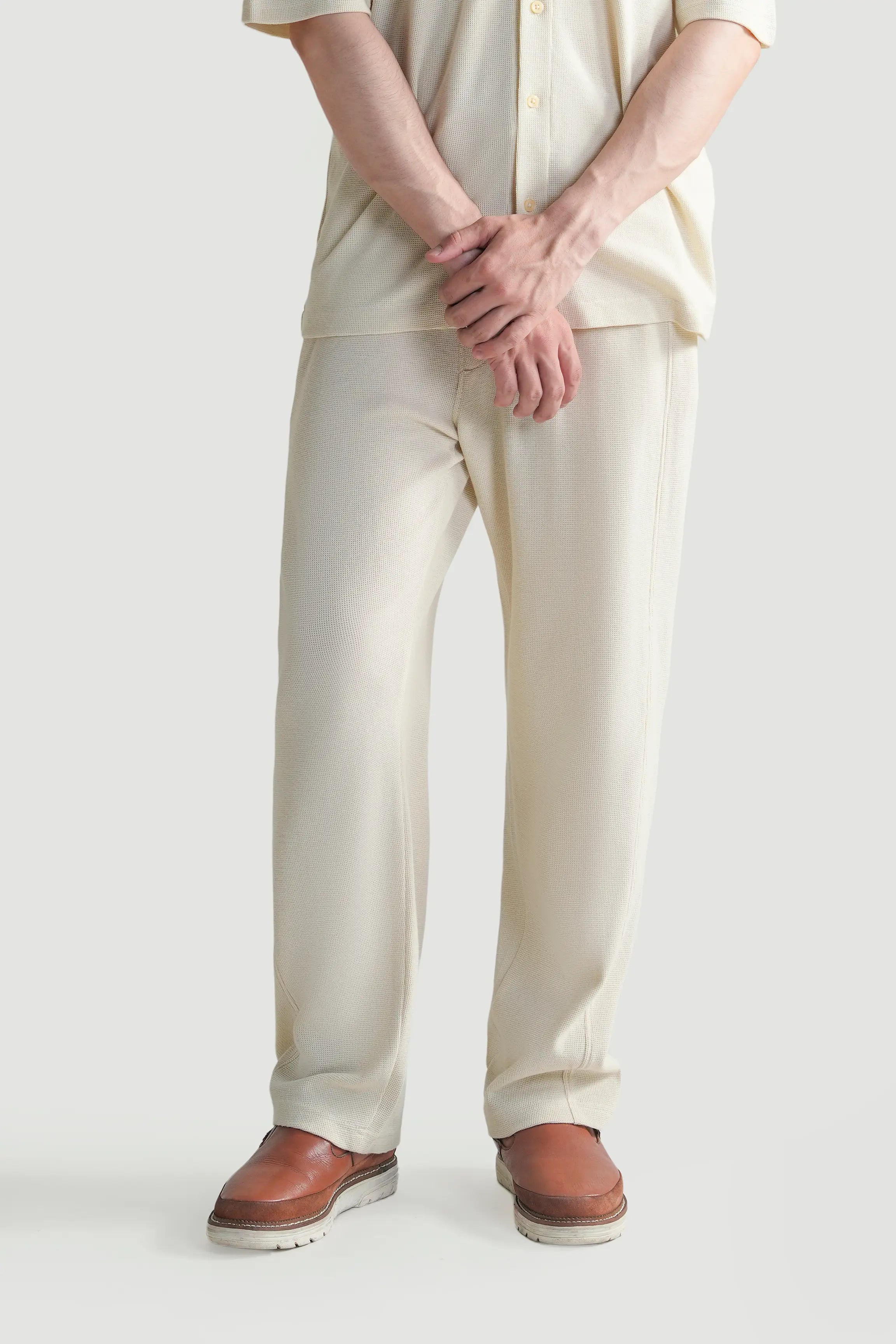 Off-white knit trousers with drawstring waist and relaxed fit