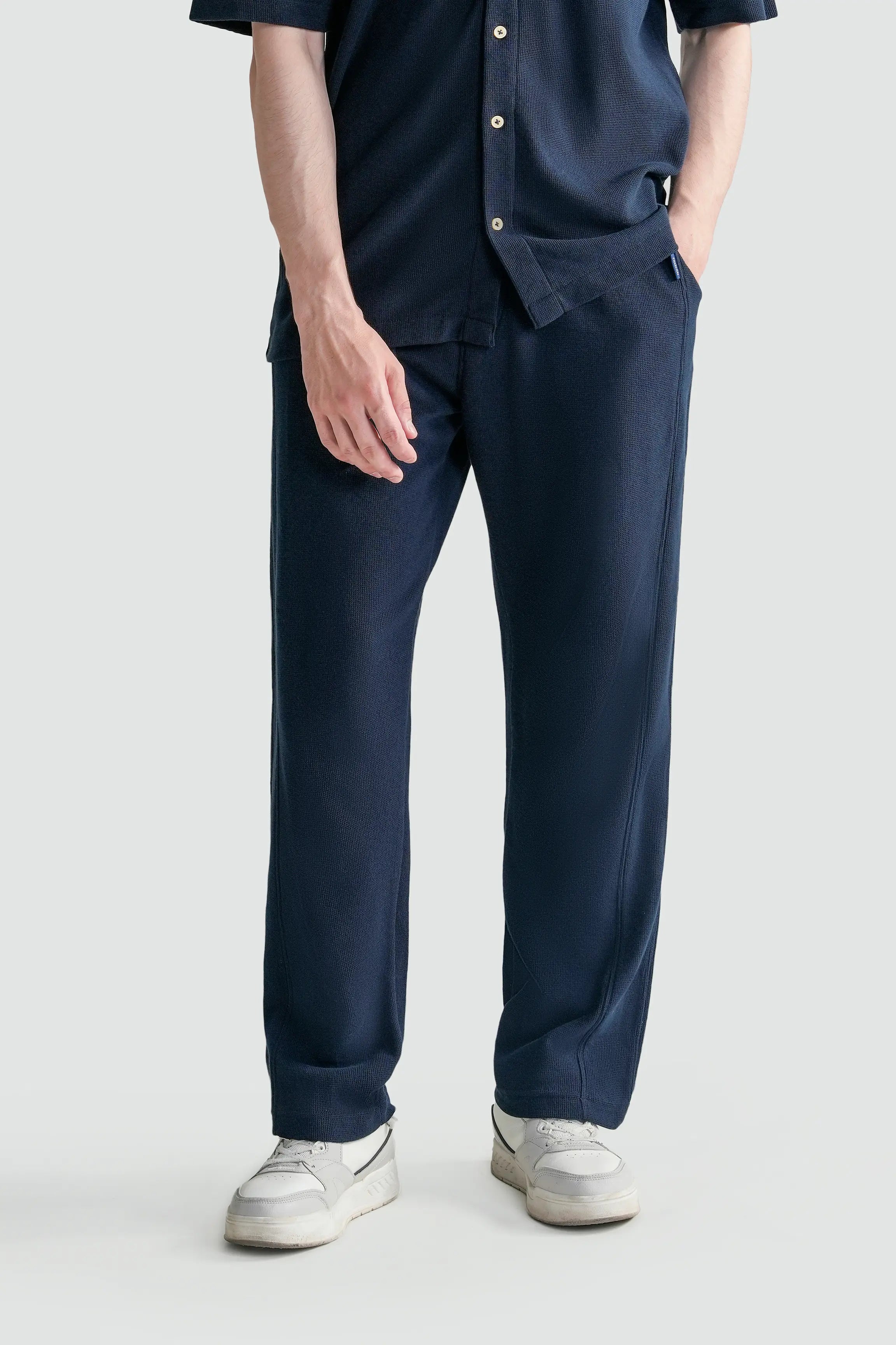 Navy loose knit trousers with straight legs, side pockets, drawstring waist
