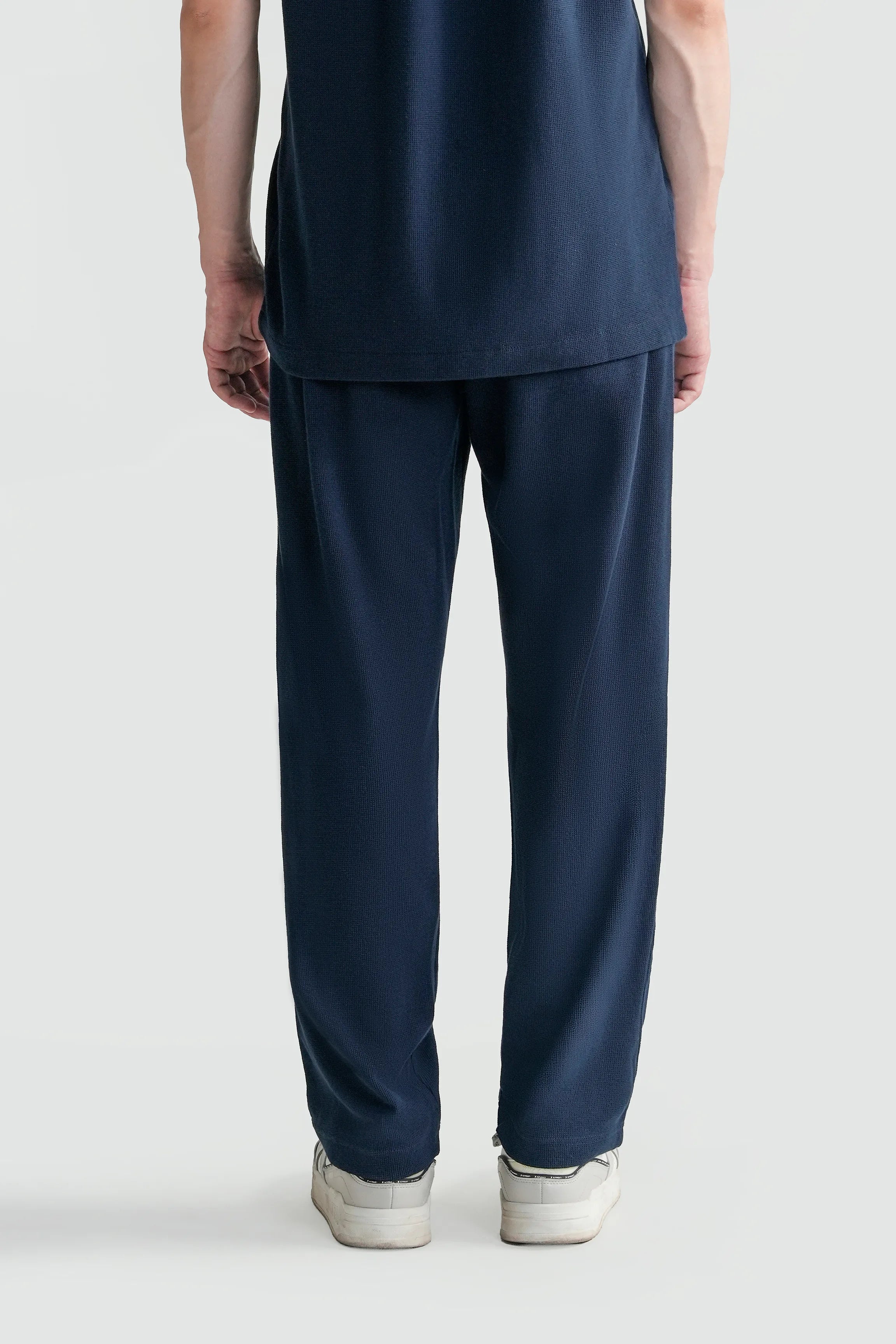 Navy knit trousers front view with straight legs and side pockets