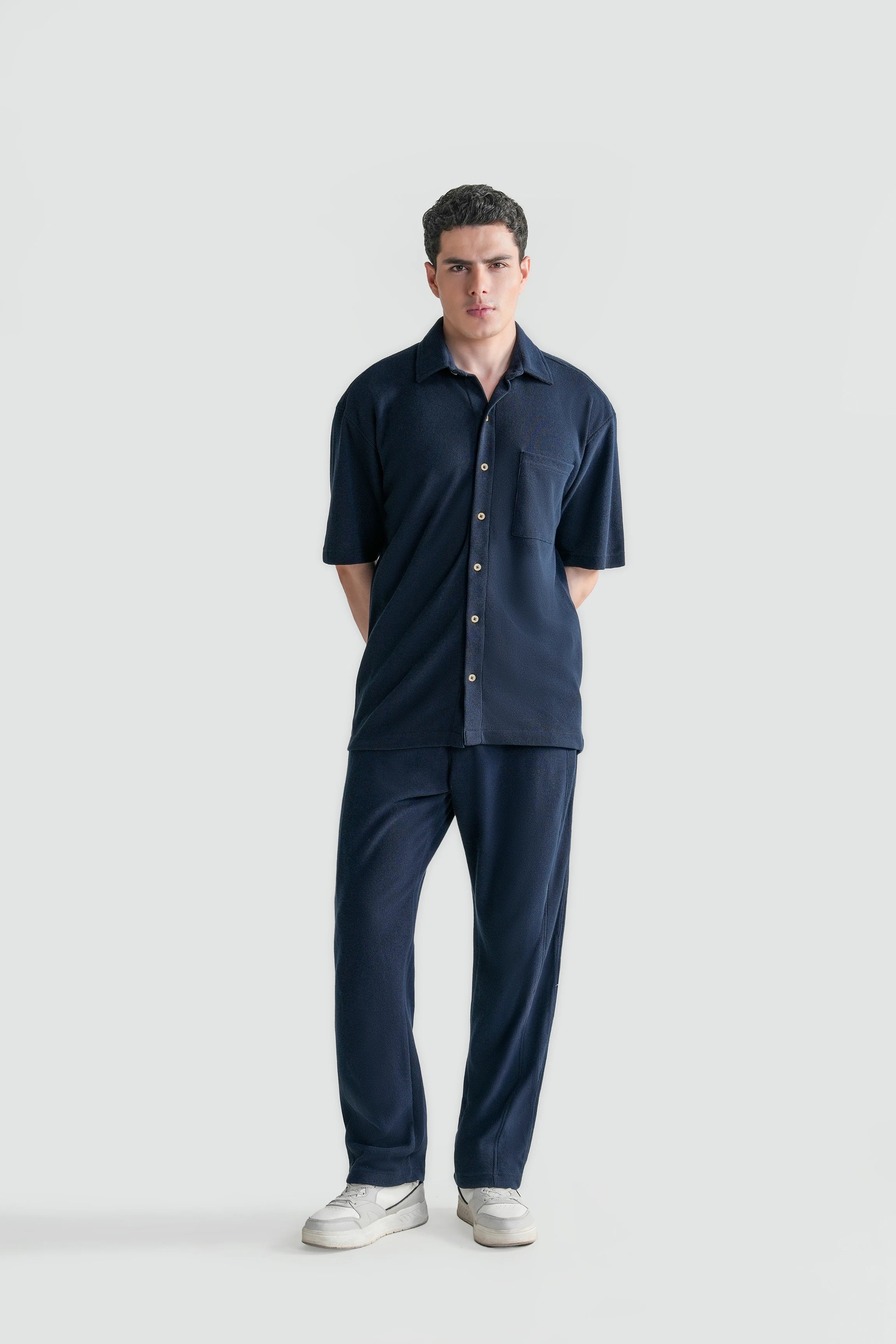 Navy short-sleeve knit casual button-up shirt with pointed collar and front buttons.