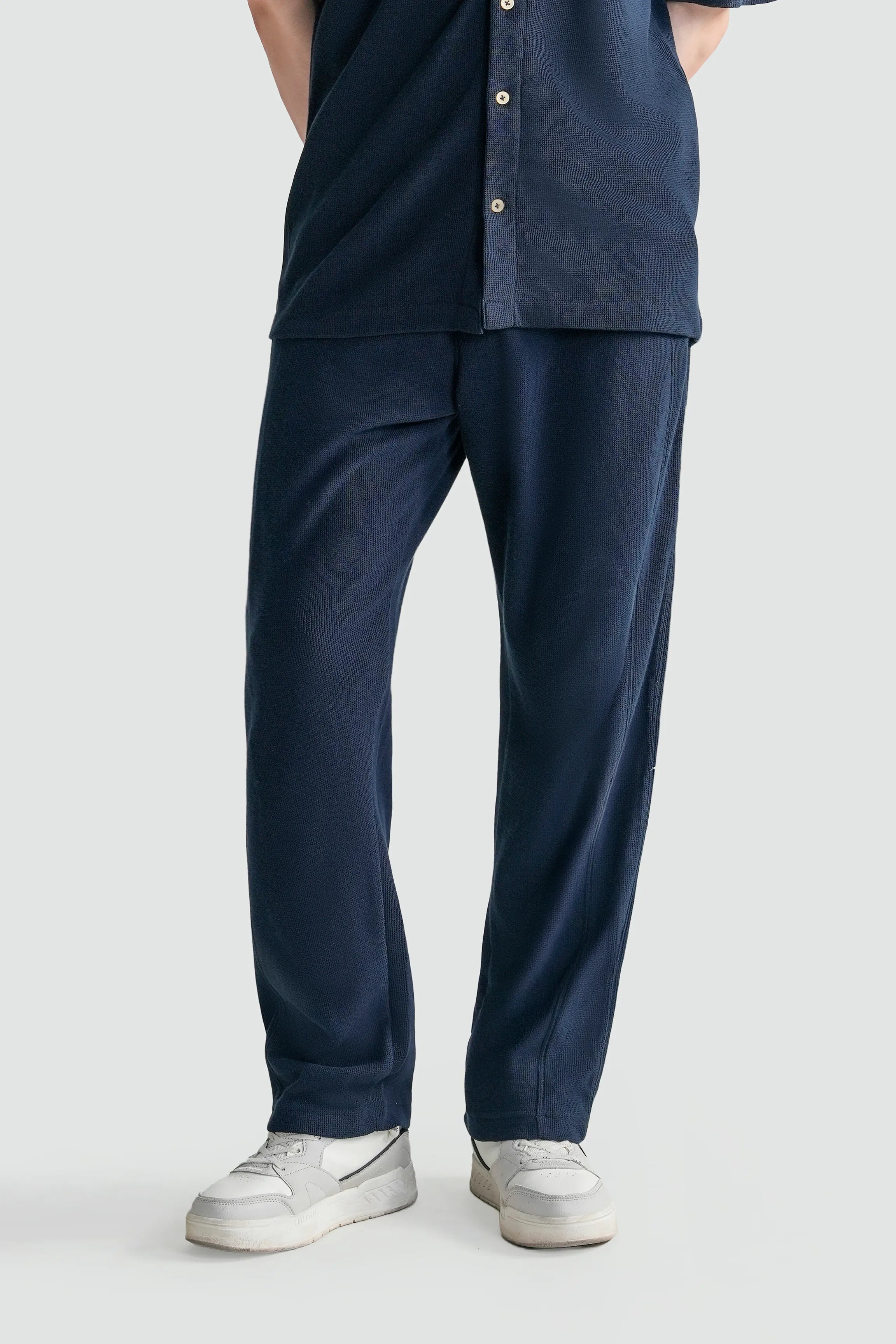 Navy knit trousers with loose fit and open hem, side pockets