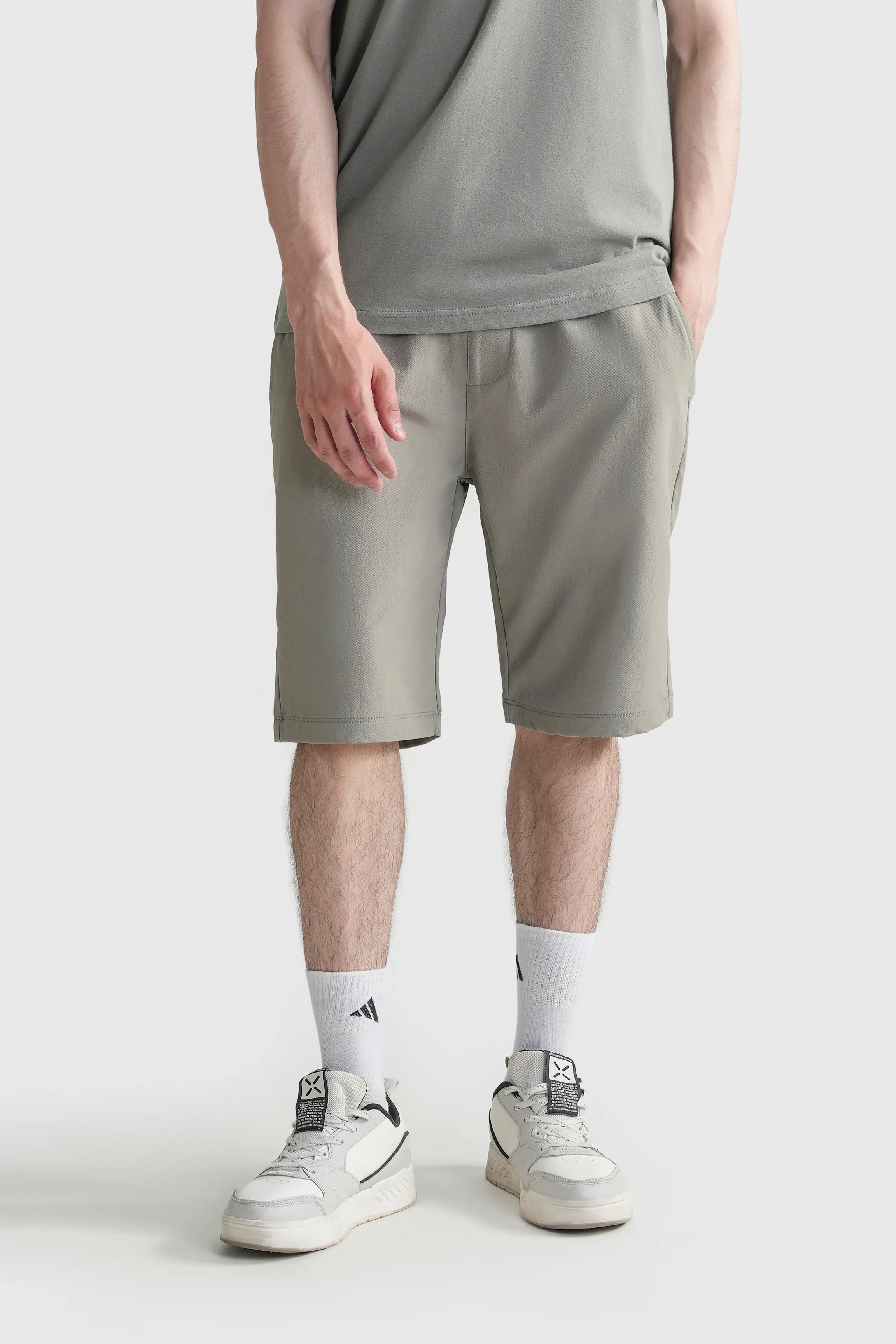 Olive regular-fit shorts with knee-length hem and side pockets.