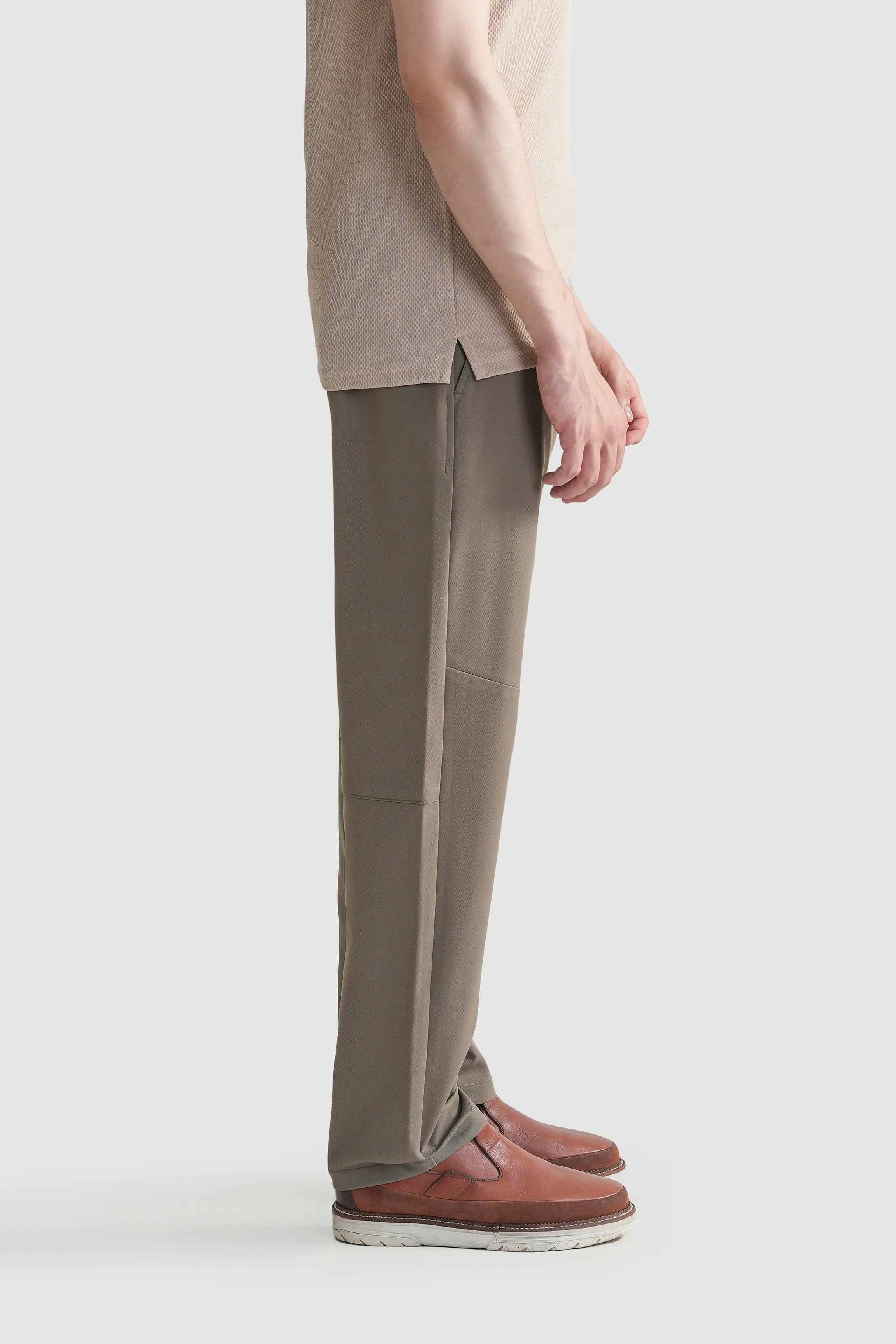 Straight-fit travel pants in light brown, side view with tapered leg and front pocket.
