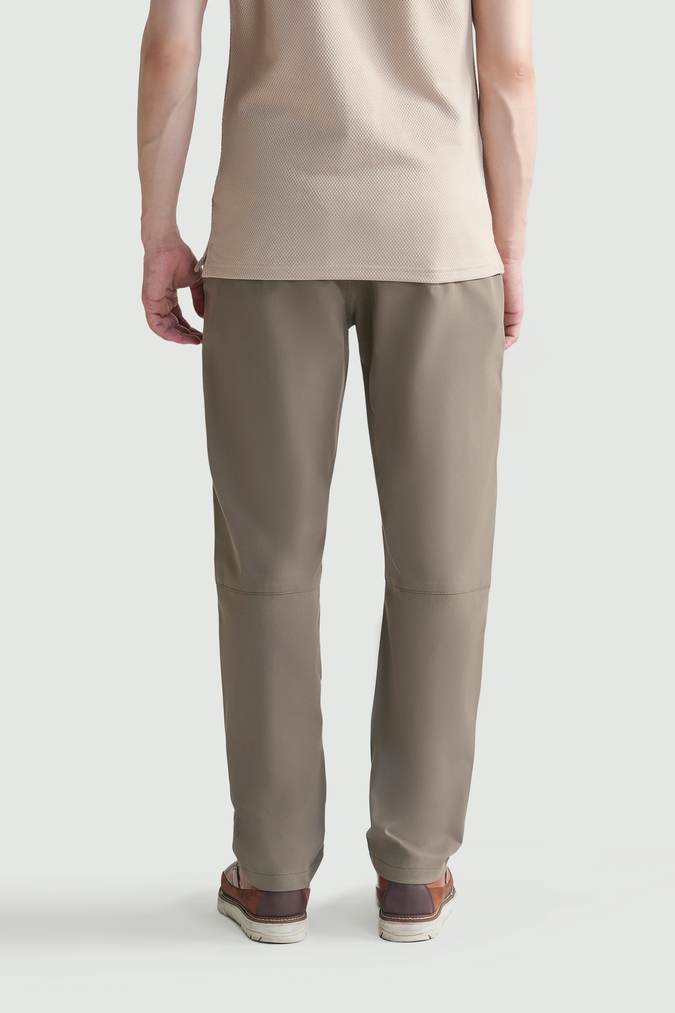 Straight-fit travel pants in light brown, front view showing straight legs and stitched seams.