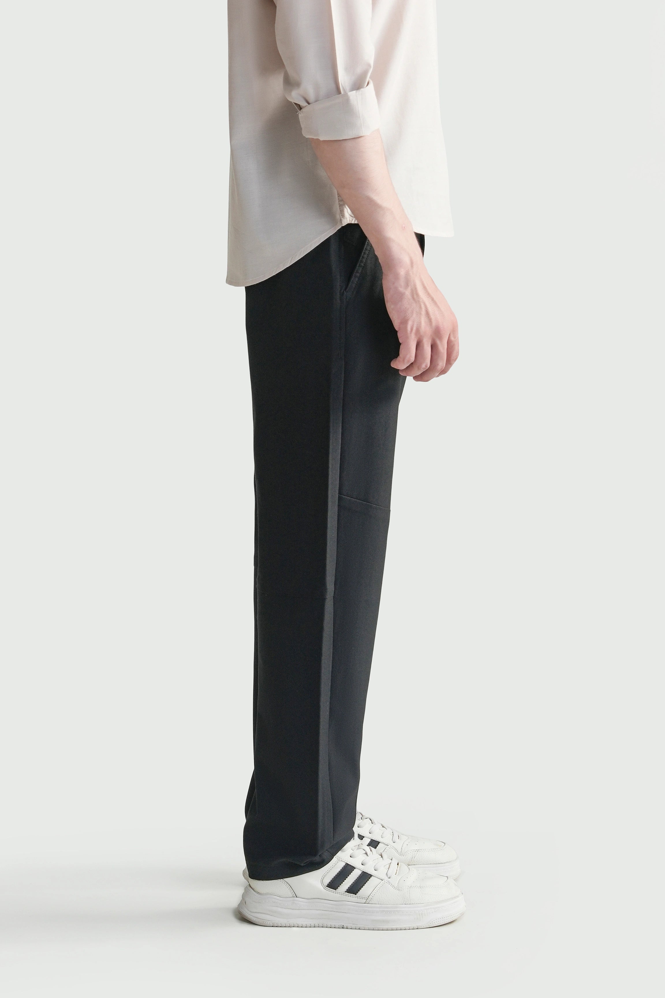 Black straight-fit travel pants, side view with straight leg and clean ankle-length hem