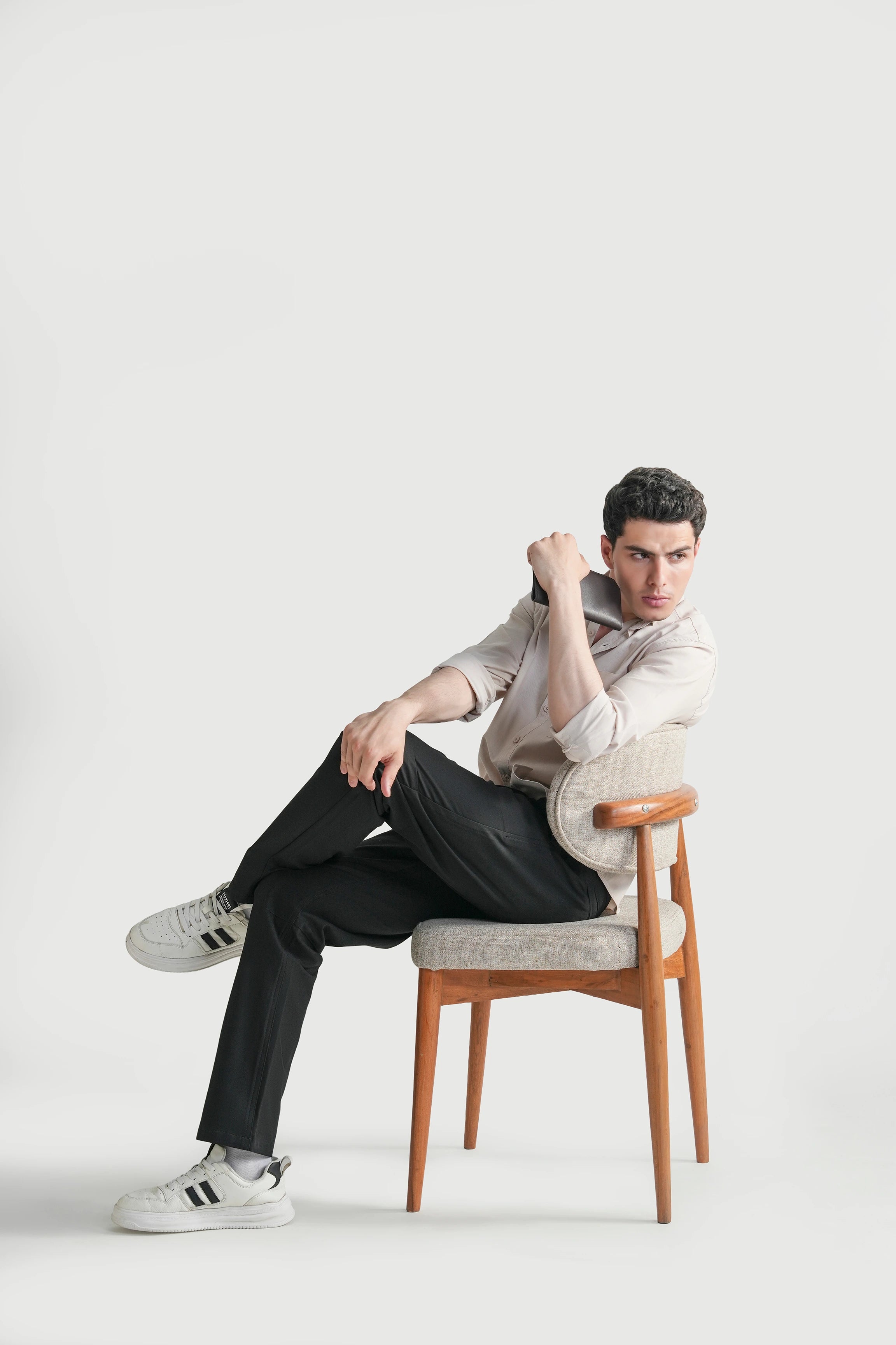 Black straight-fit travel pants with straight legs and ankle-length hem, worn seated