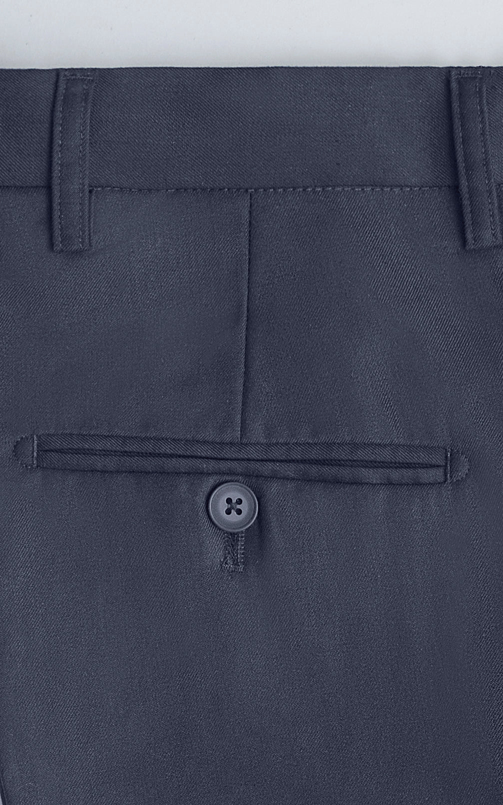 Navy dress pants waistband close-up with button closure and belt loops