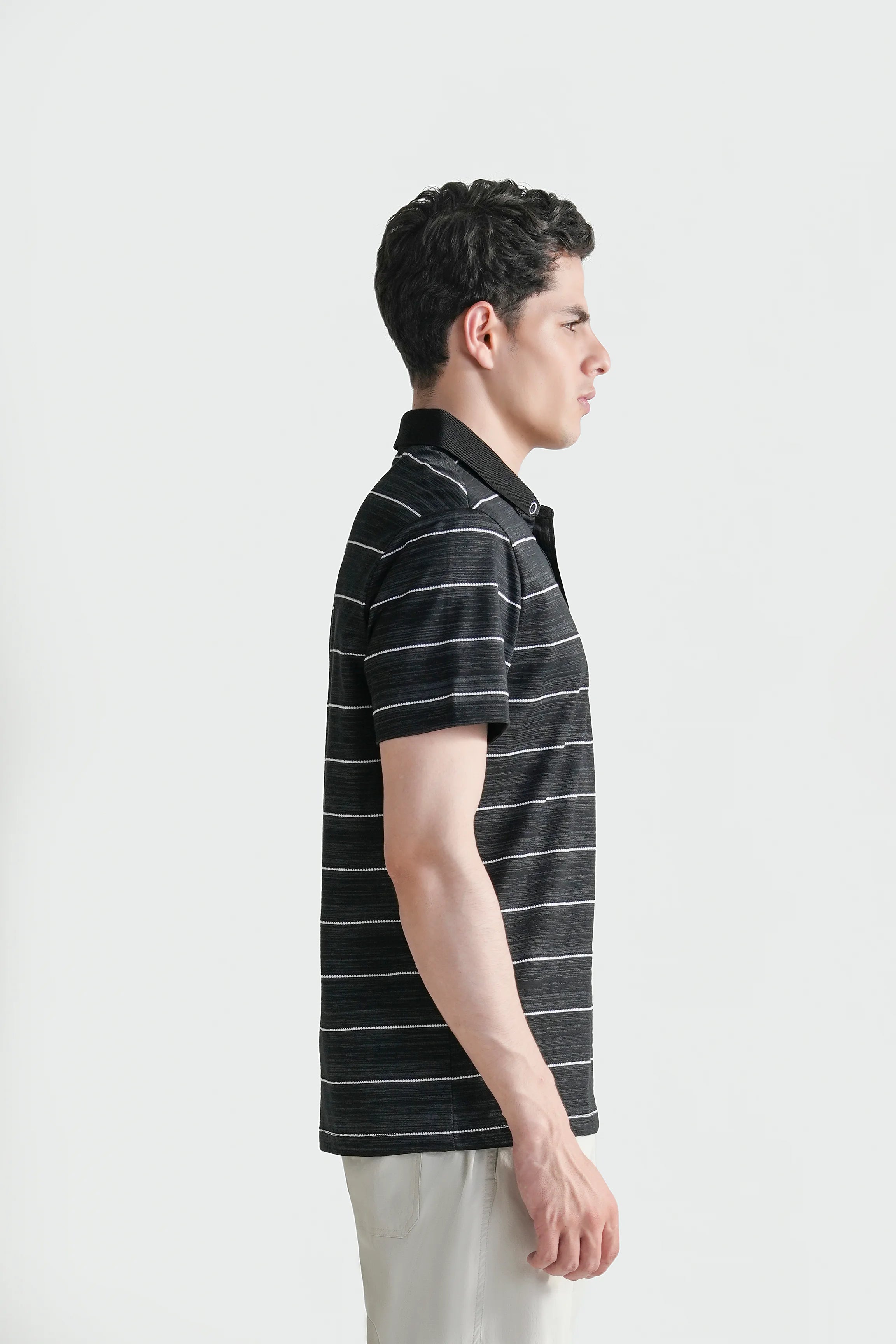 Men's black striped polo shirt shown from the side with short sleeves