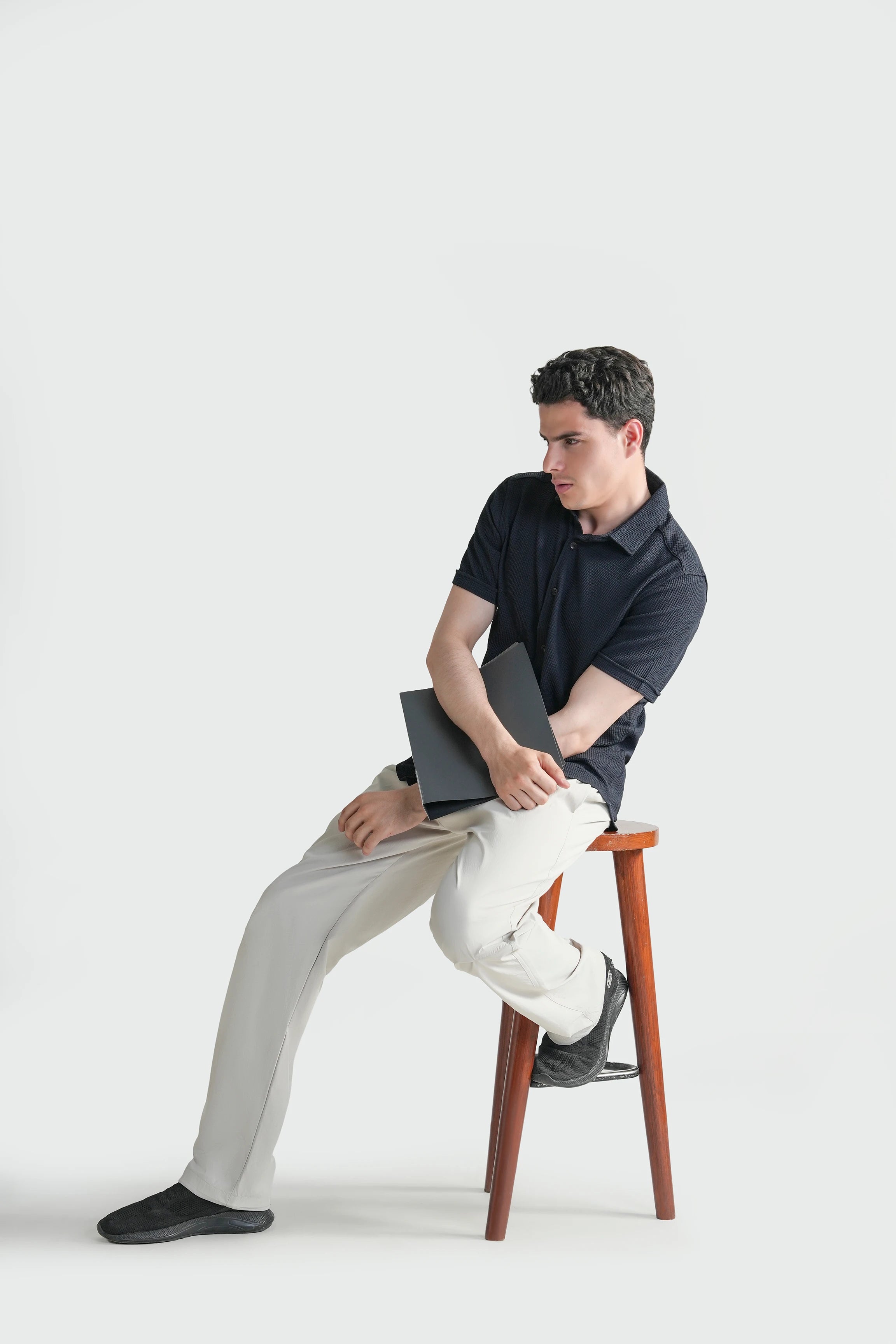 Navy self-textured casual shirt with button front and short sleeves, seated pose
