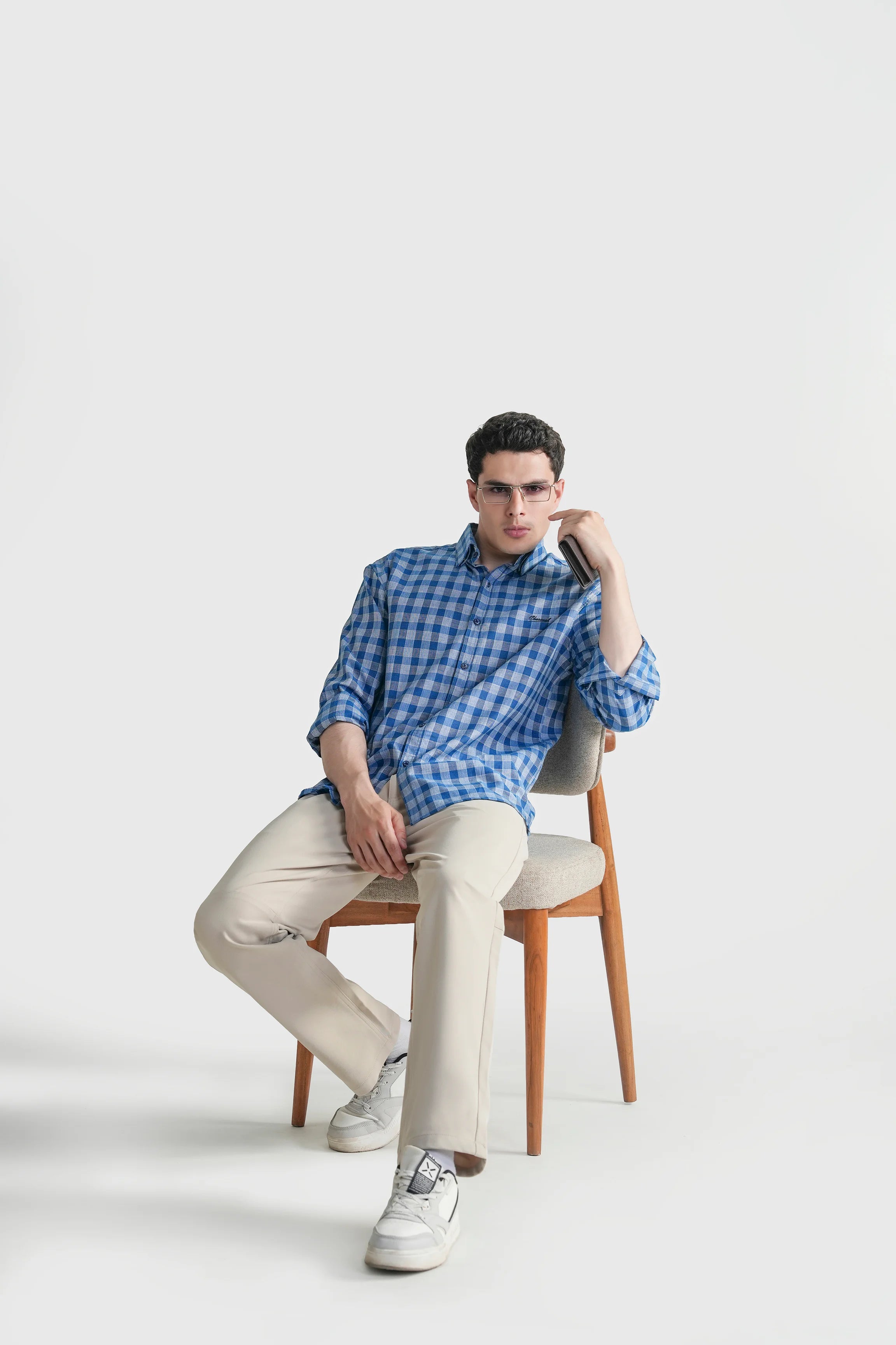 Blue and white checkered button-down casual shirt, seated pose