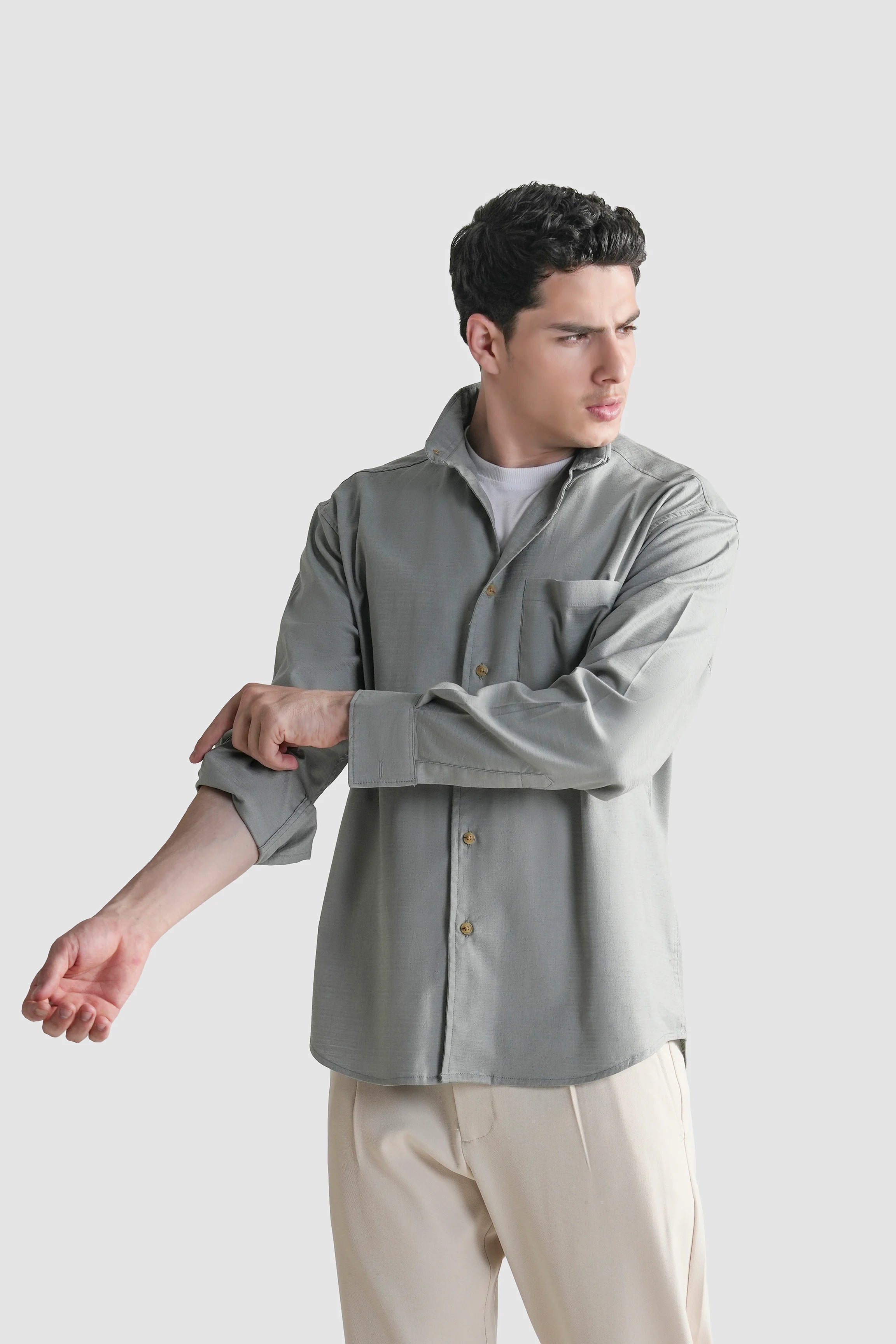 Grey button-down casual shirt, long sleeves, worn casually with open collar.