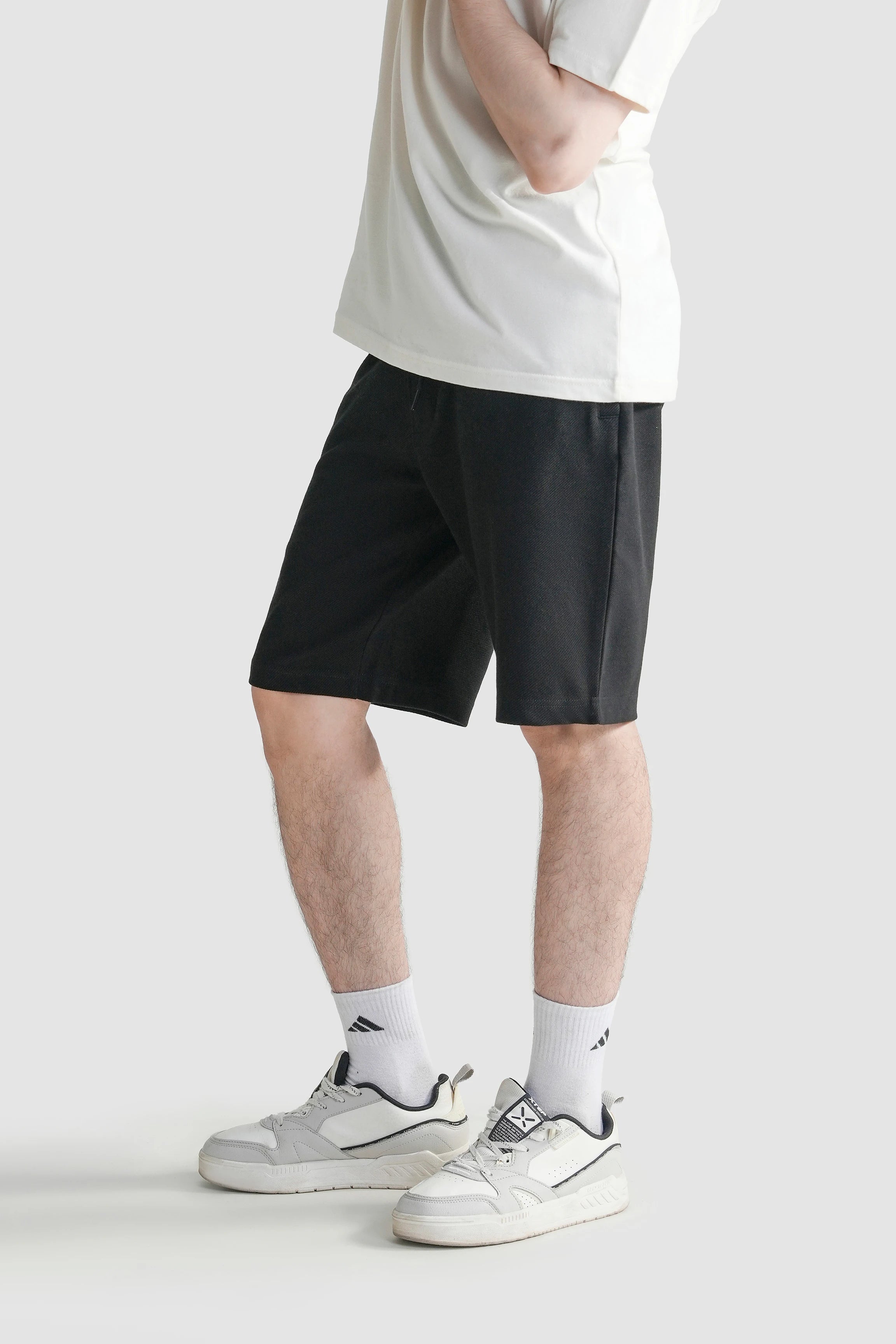 Black regular-fit shorts with elastic waistband and drawstring, mid-thigh length