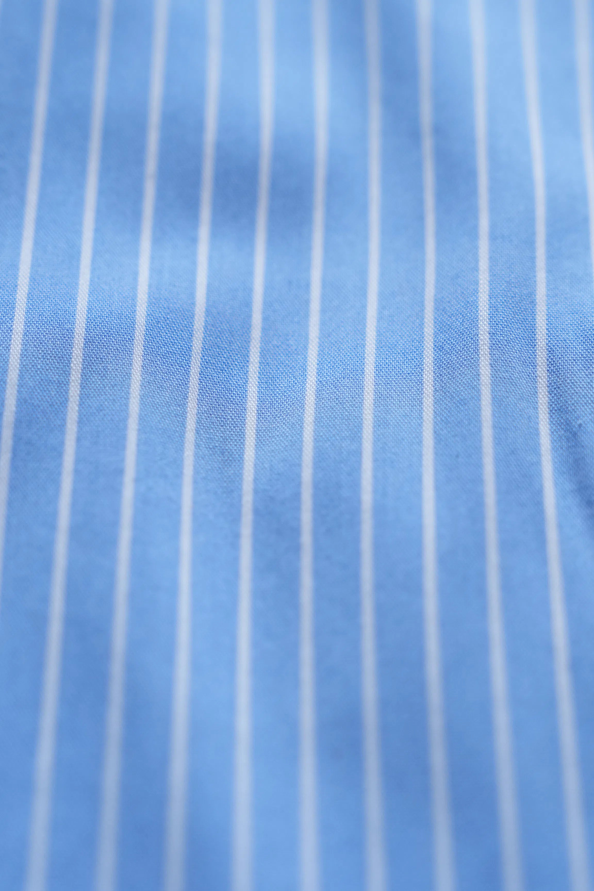 Light blue striped dress shirt fabric texture with thin light pinstripes