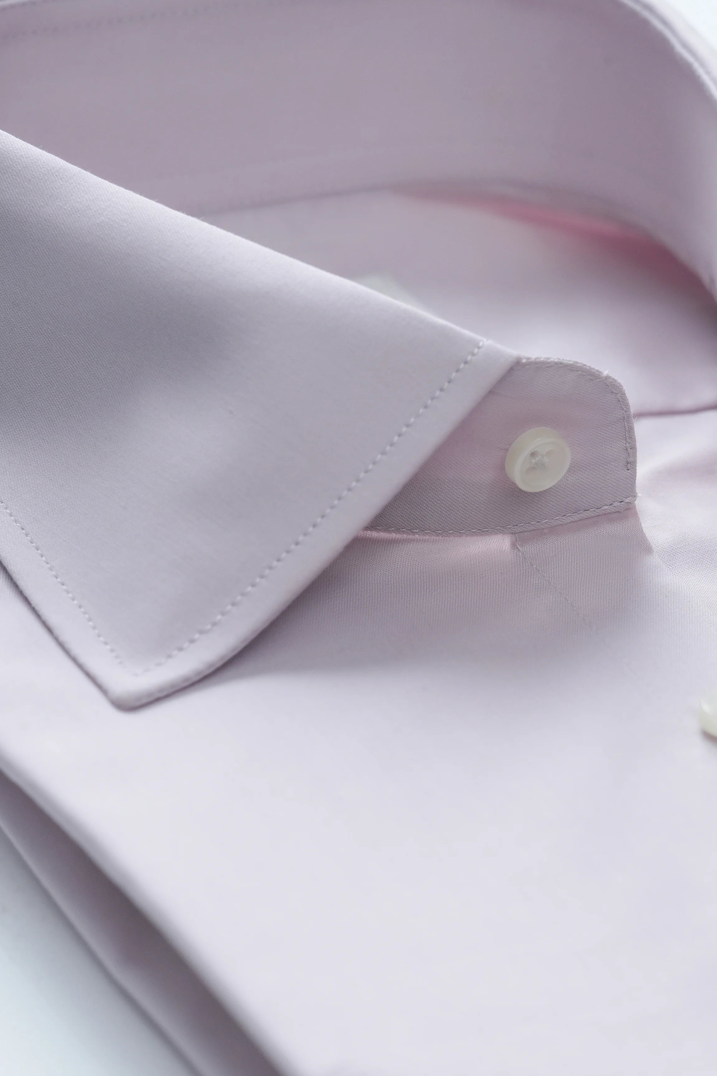 Tea pink dress shirt close-up of collar edge and buttoned placket