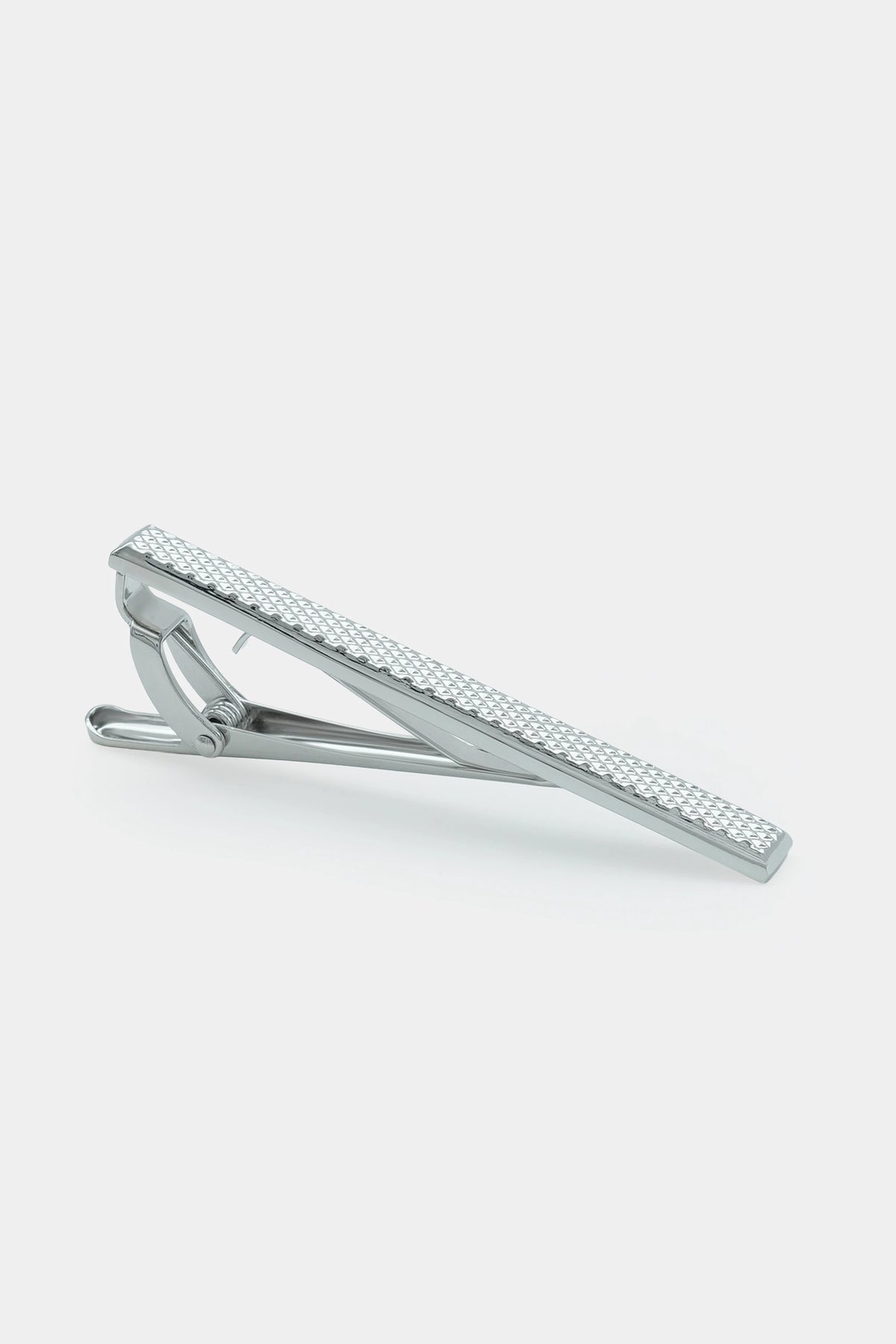 Silver textured tie pin with hinged clasp, angled view