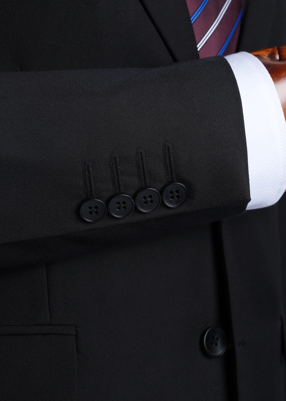 Black suit sleeve cuff with four buttonholes and subtle textured stitching