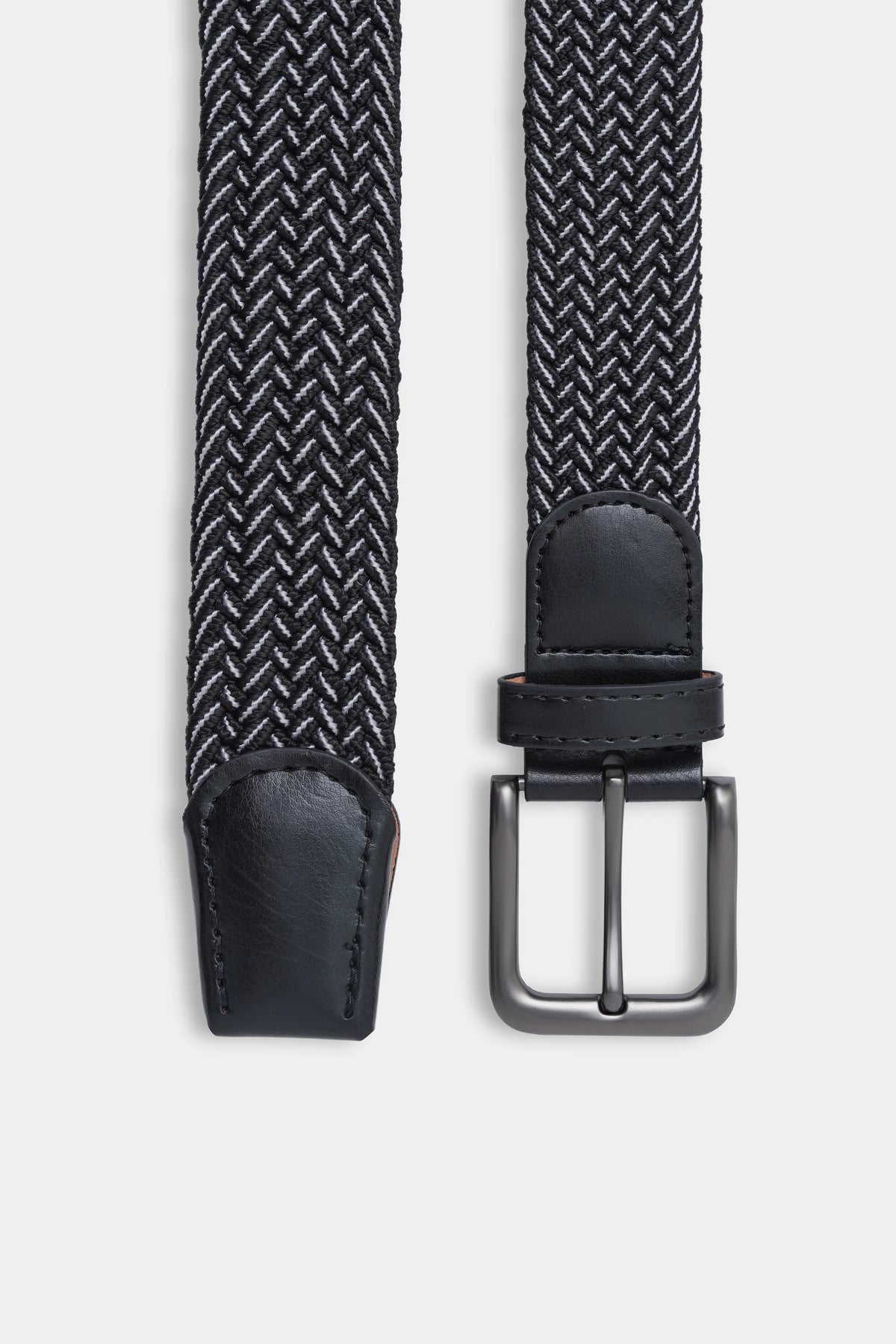 Woven belt close-up with black leather end loop and rectangular metal buckle