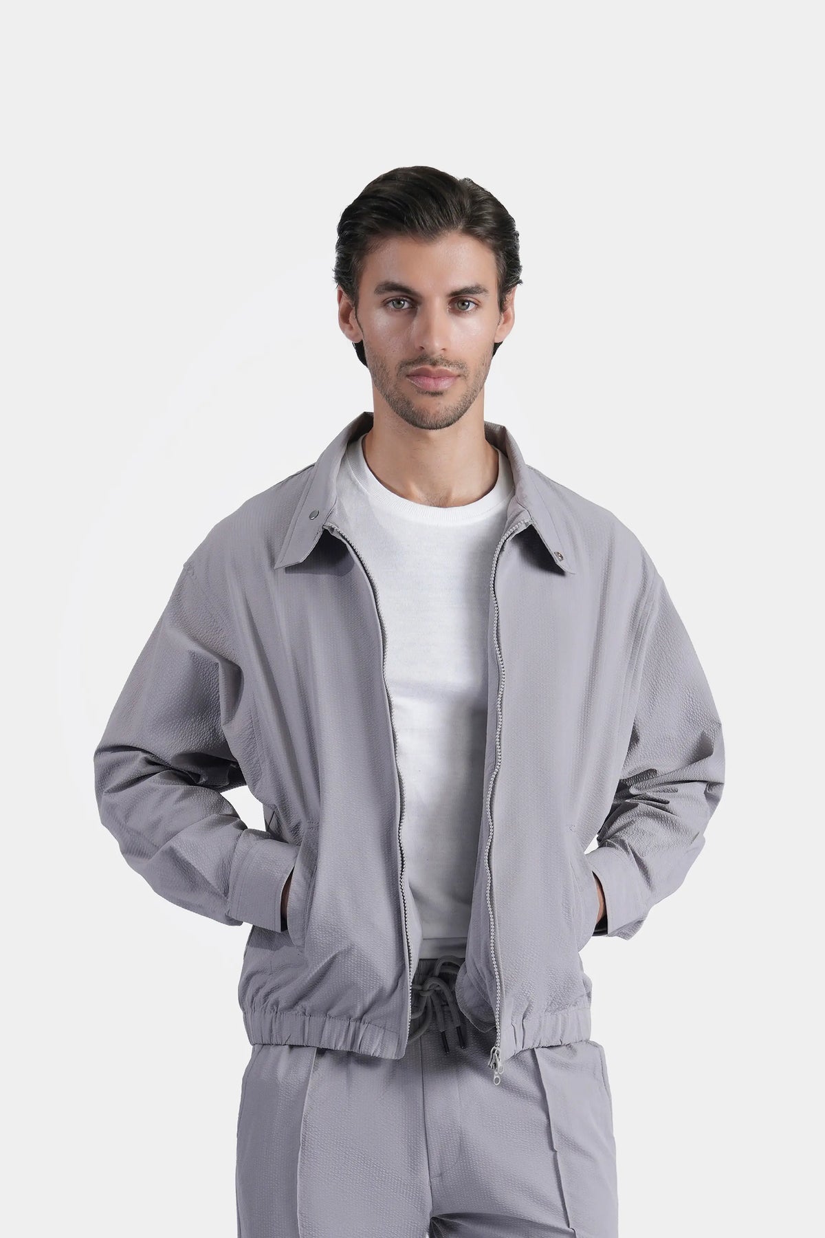 Light grey zip-up raglan jacket with stand collar, elastic cuffs, and zipper