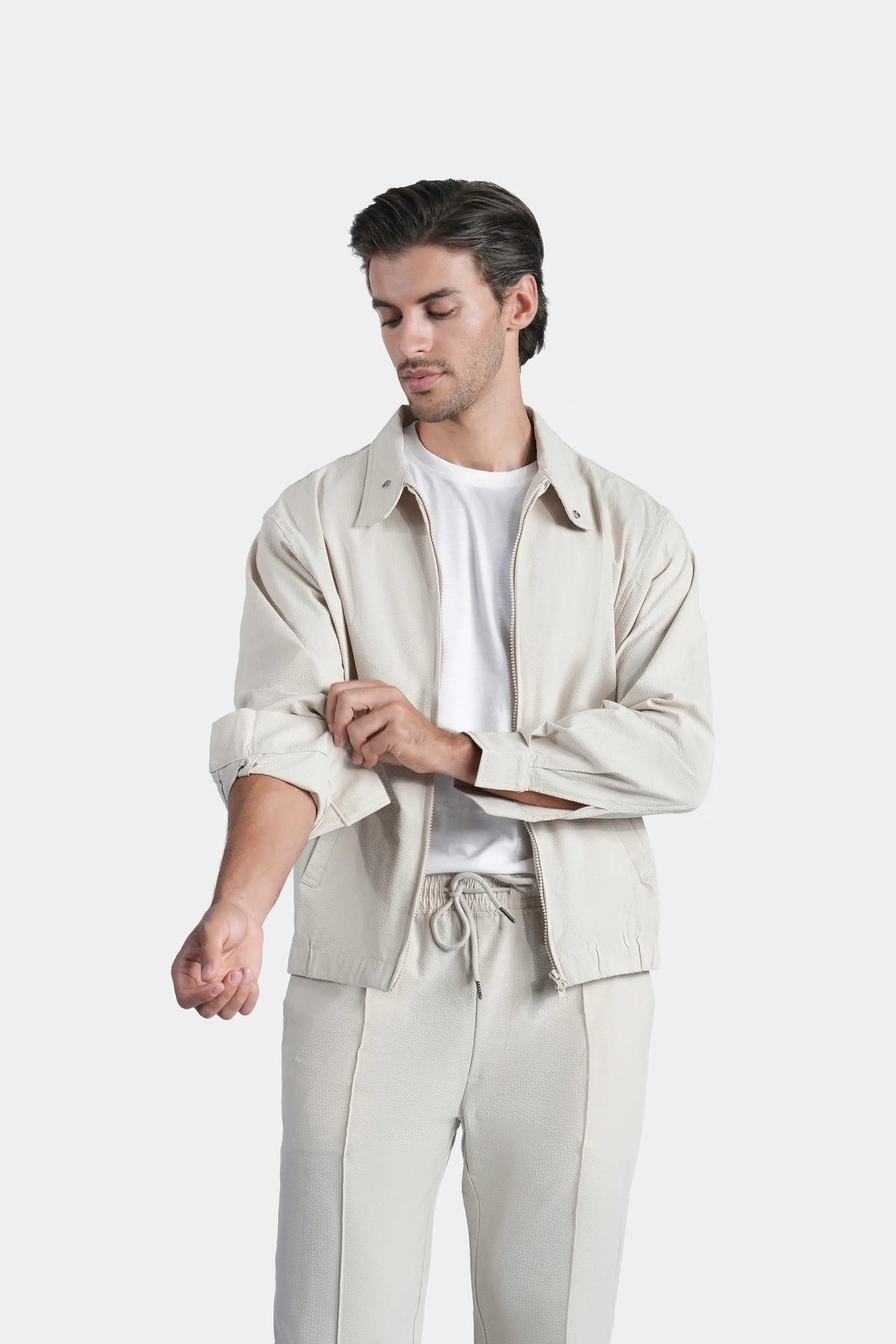 Beige seersucker jacket with raglan sleeves, front zip, and pointed collar