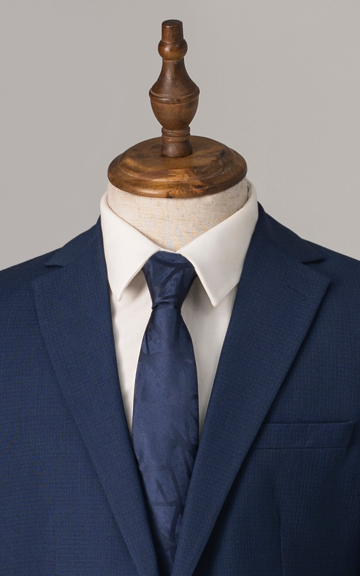 Blue suit jacket with notch lapel, white shirt, and blue striped necktie
