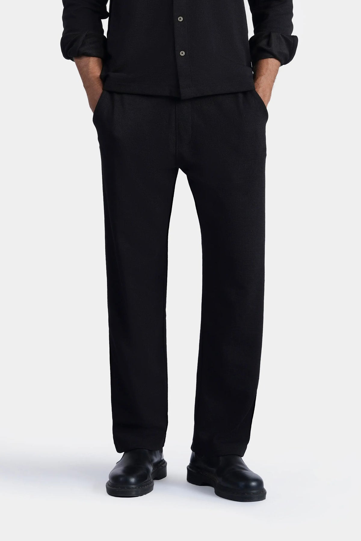Loose-fit black trousers with cuffed ankles and side seams