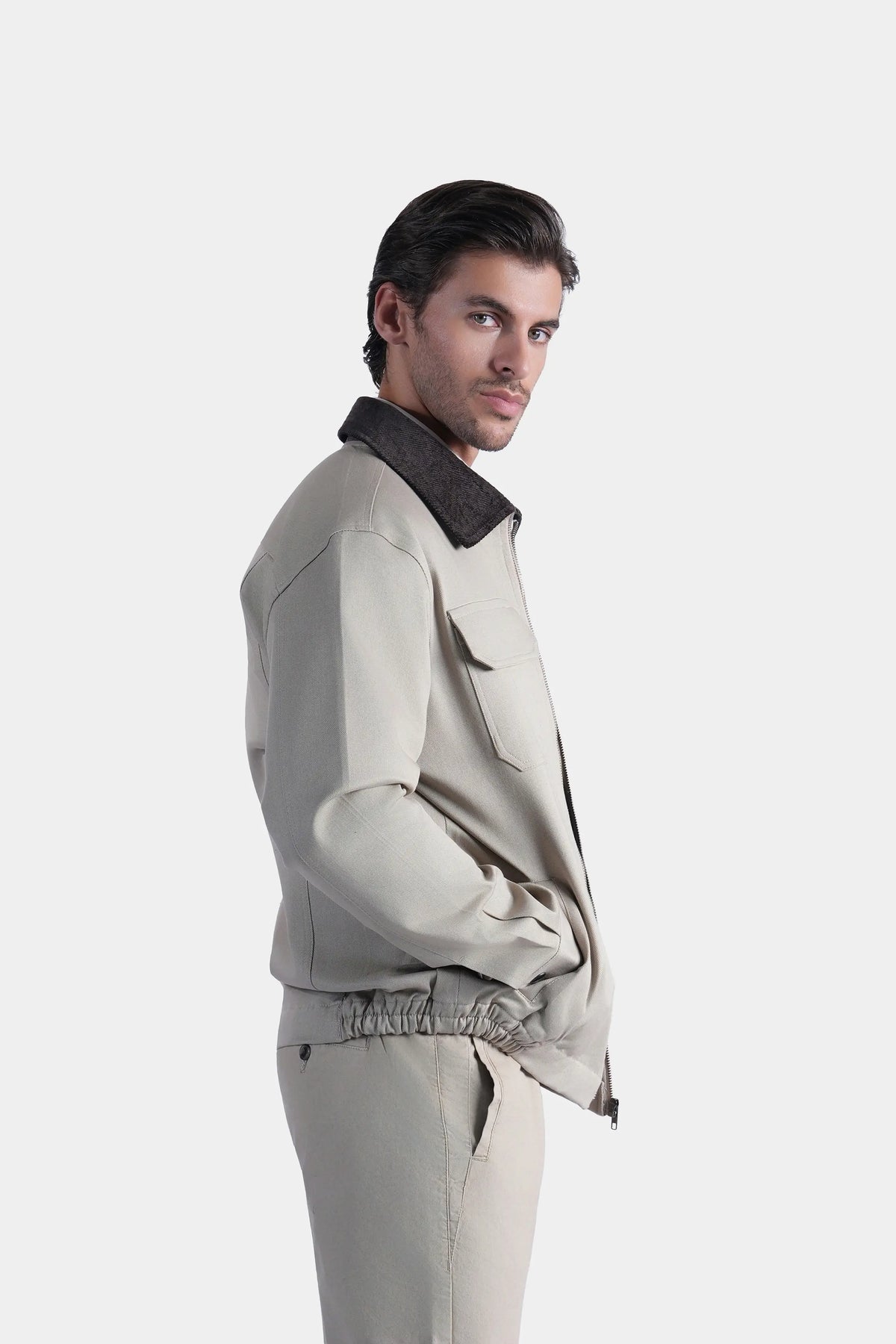 Khaki jacket side view with dark stand collar and flap chest pockets