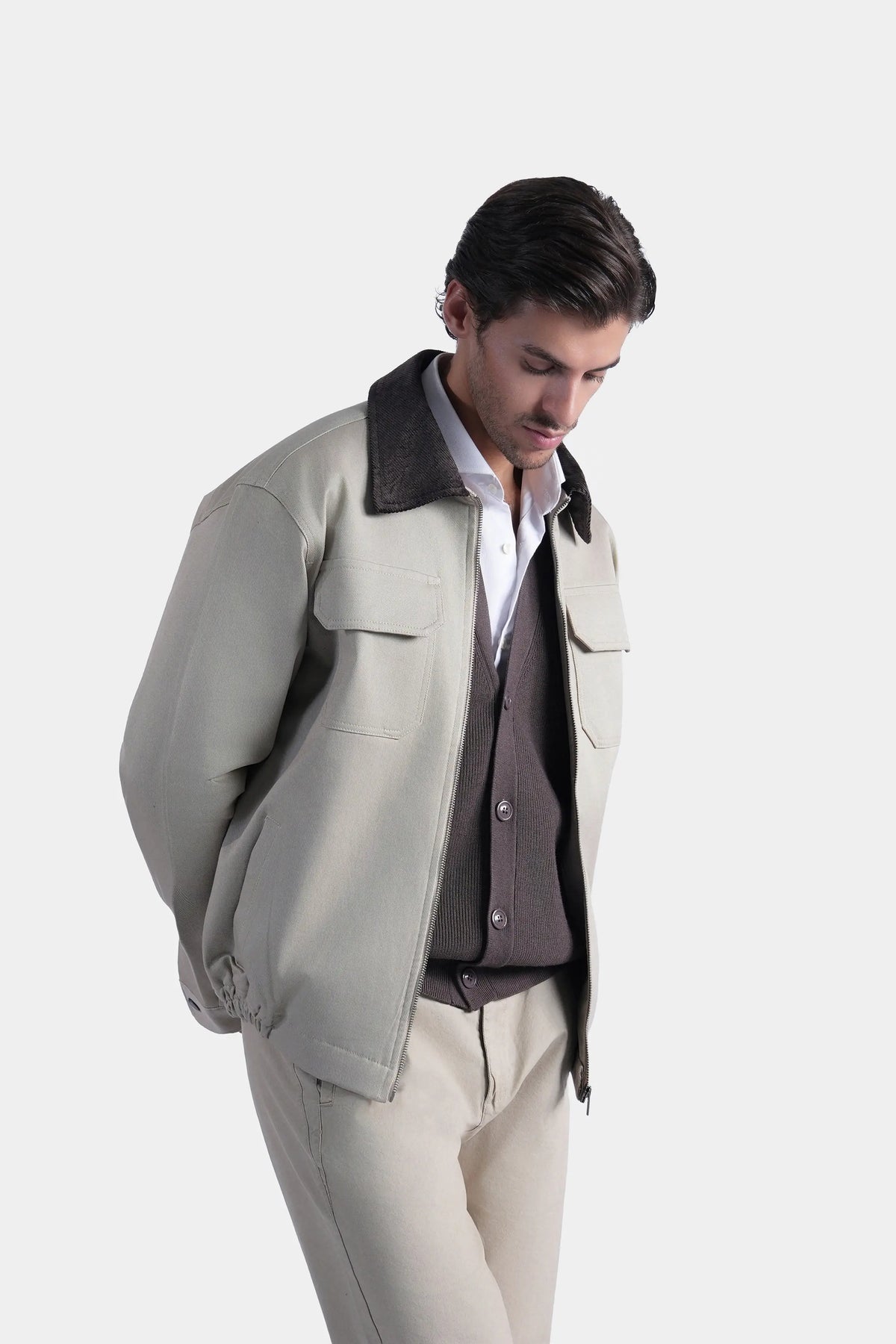 Khaki jacket with dark collar, chest pockets, and relaxed long sleeves