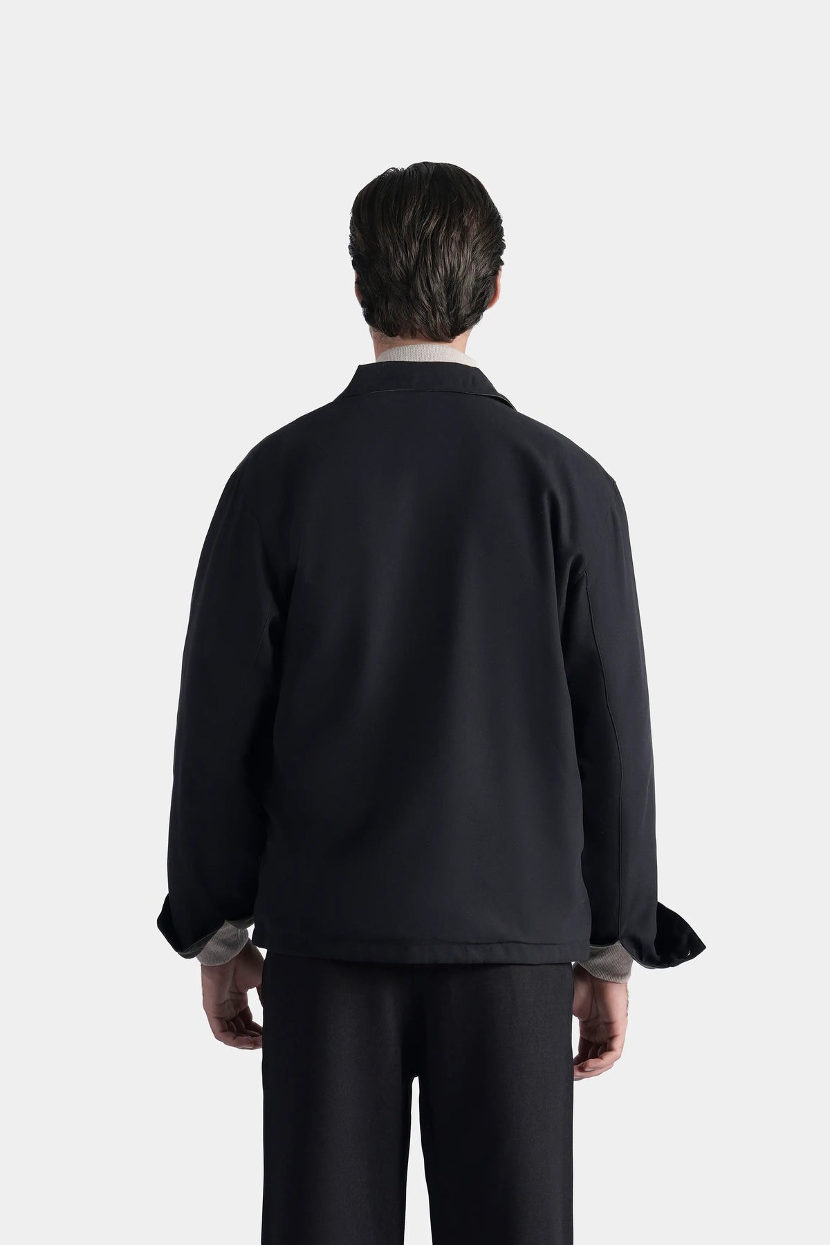Black reversible collar jacket back view with zipper and elastic cuffs
