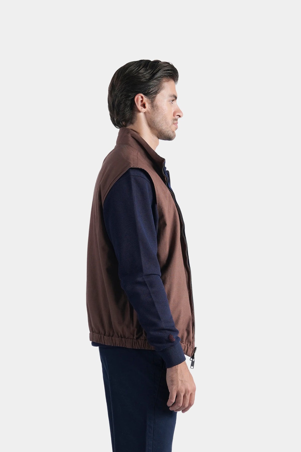 Reversible sleeveless jacket in rust-brown with stand collar and front zipper, side view