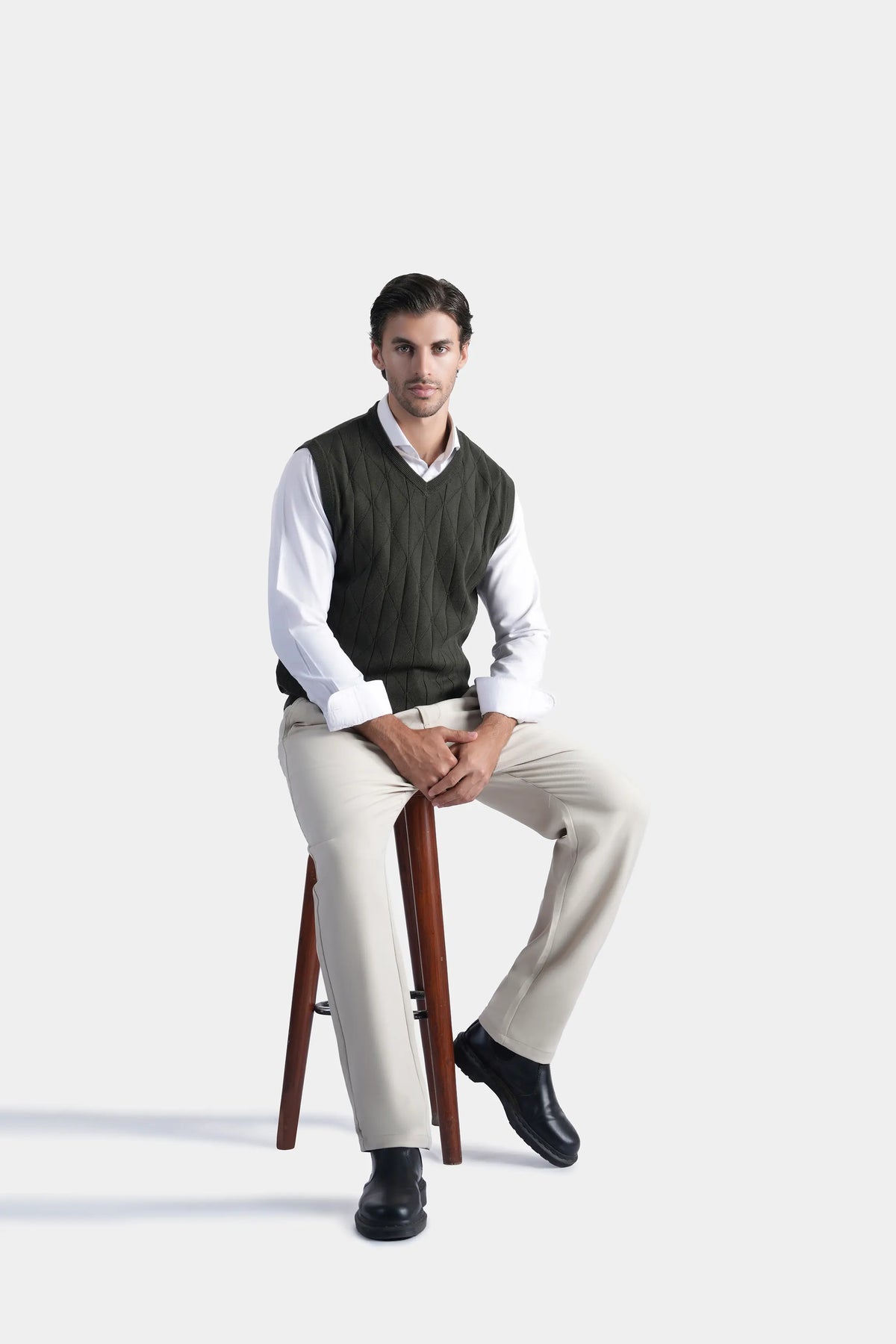 Sleeveless knit V-neck sweater vest in dark color, seated front view