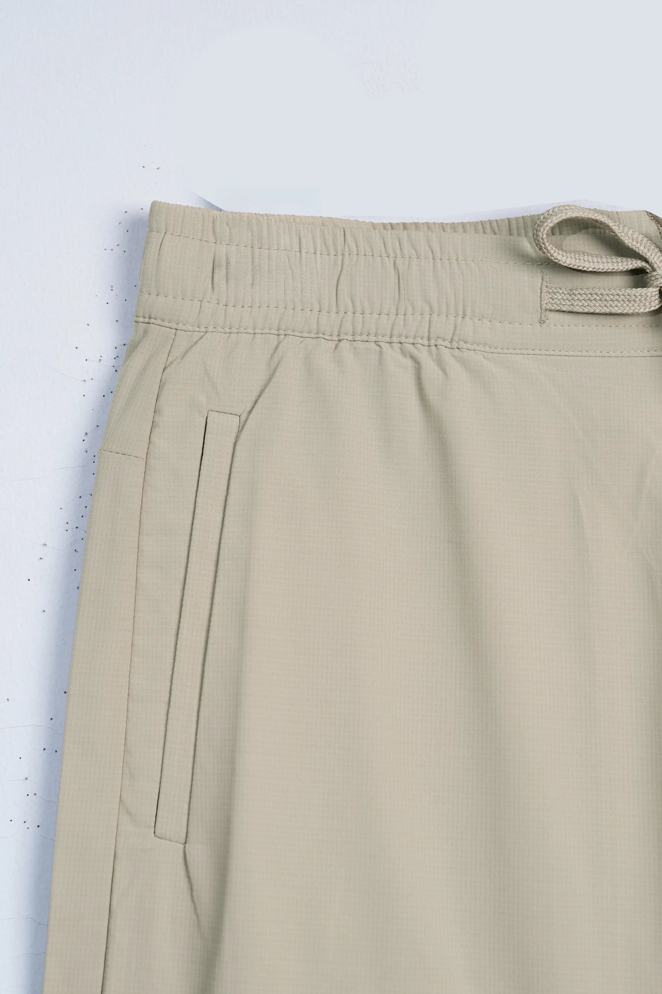 Beige trousers waistband with belt loops and drawstring tie