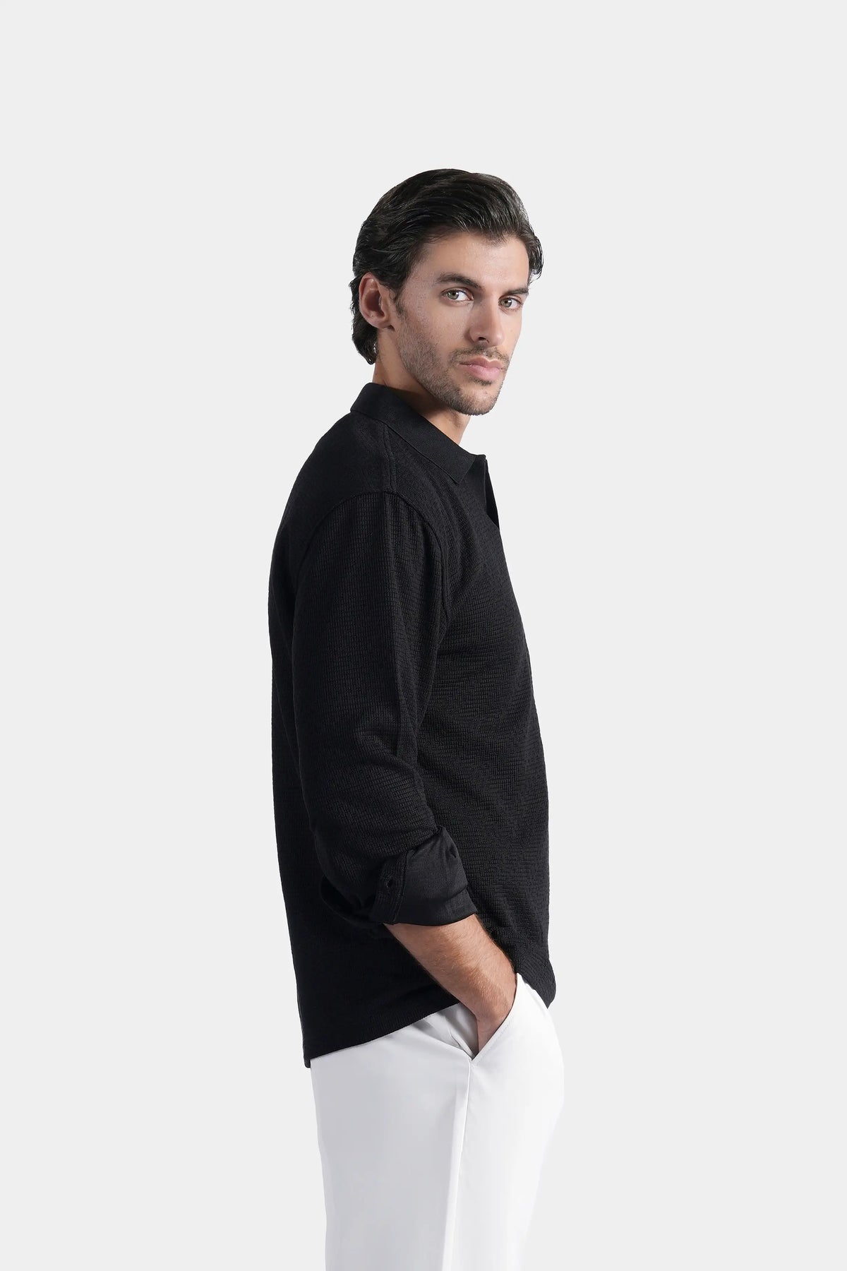 Black long-sleeve polo shirt with button placket and self-textured fabric, side view
