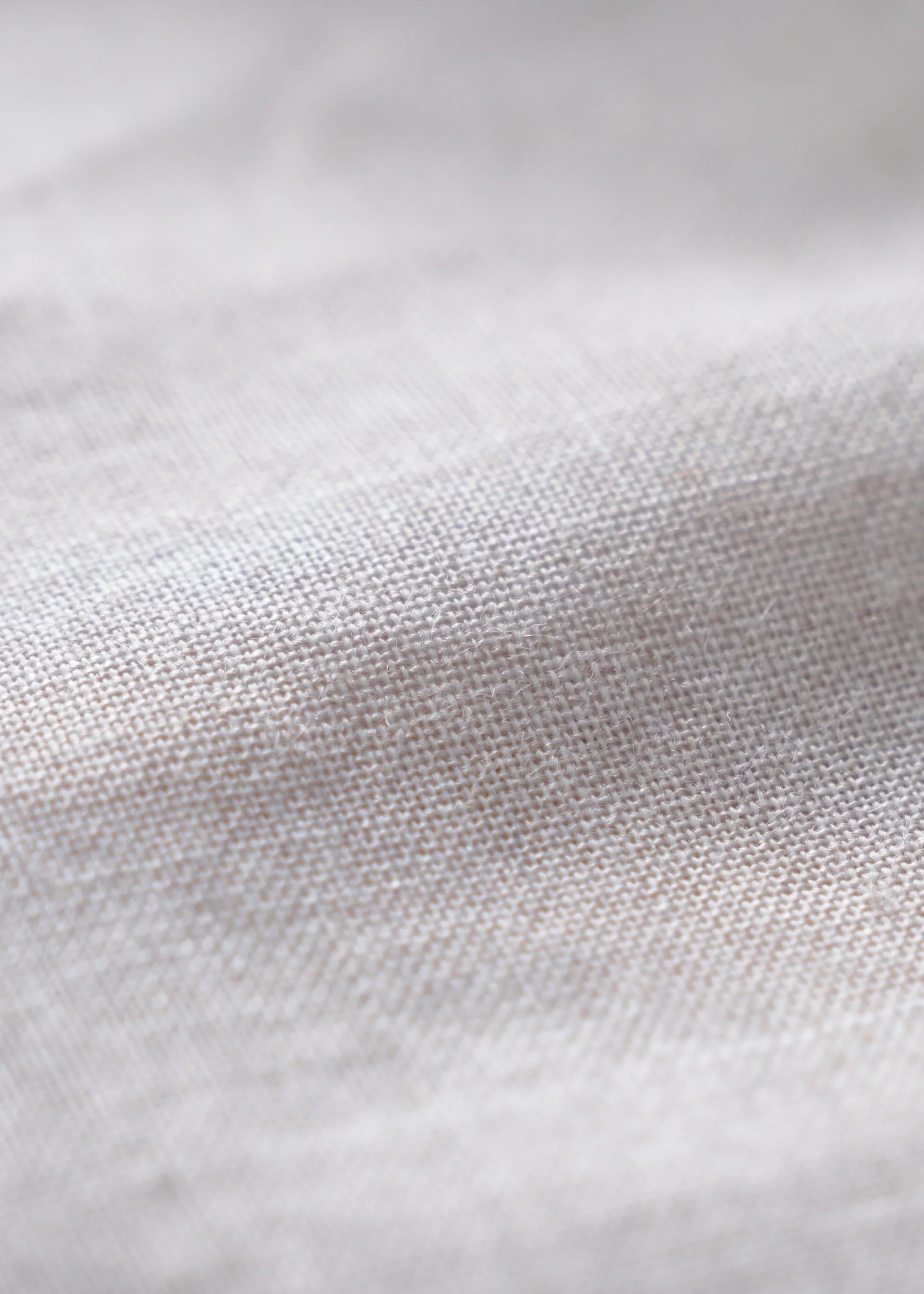 Light oatmeal linen fabric with fine woven texture close-up