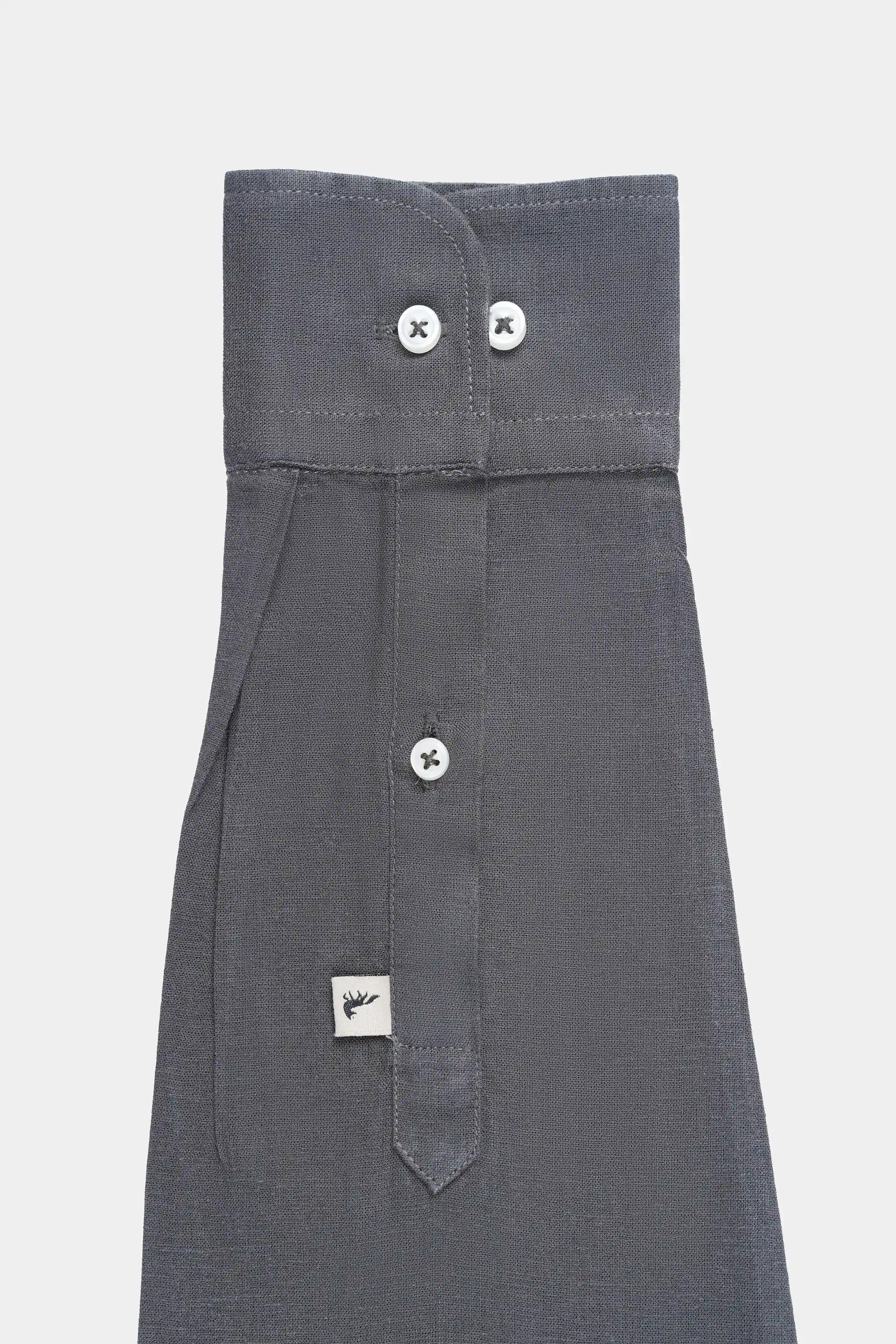 Black linen shirt partial view with woven tag and buttoned placket