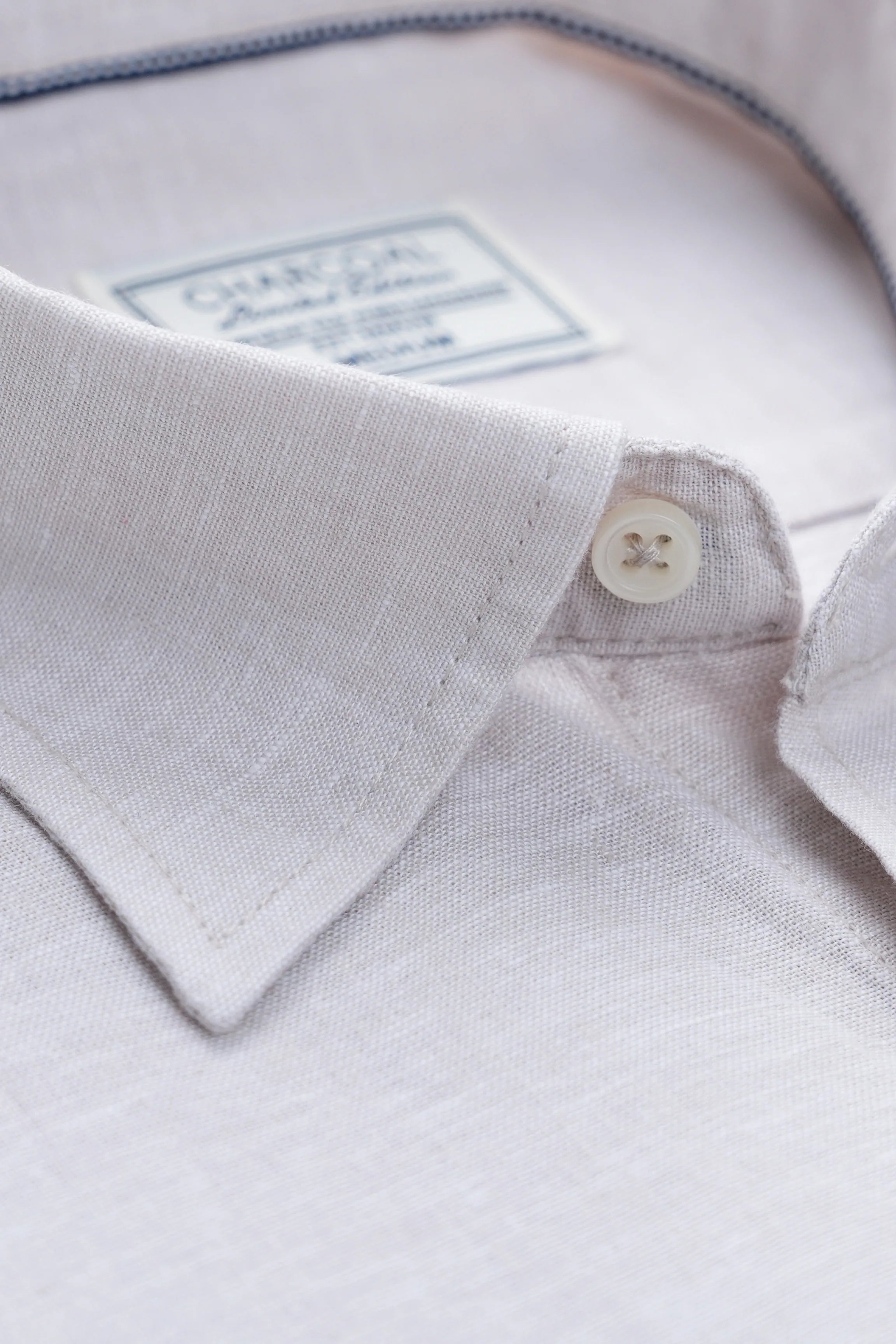 Linen collar close-up with button placket and small brand label