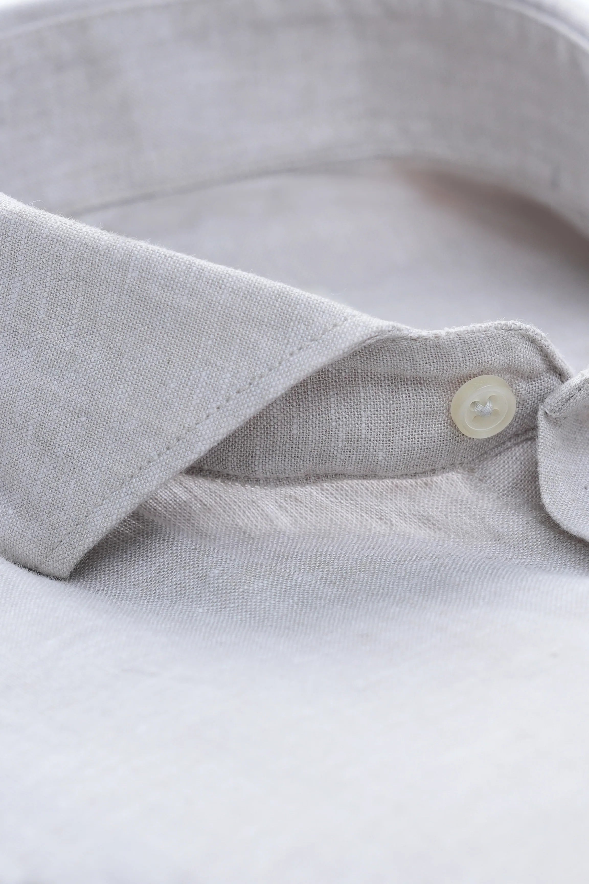 Linen shirt collar close-up with white button and wide spread